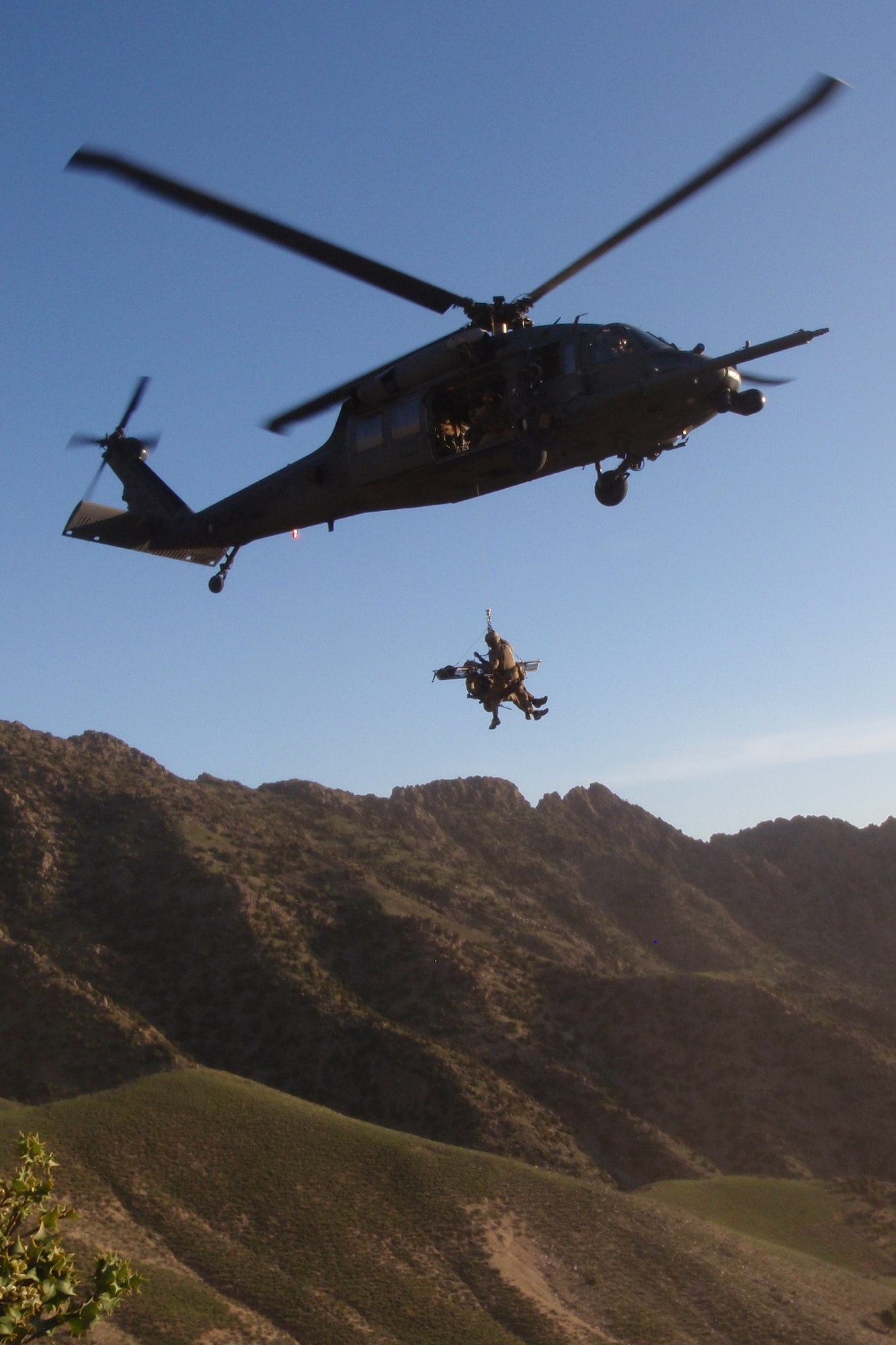 Maj. Jesse Peterson and Tech. Sgt. Shane Hargis, 83rd Expeditionary Rescue Squadron Guardian Angel team members, practice a hoist mission, April 22, 2011, the day before they were called upon to recover the pilots of a downed Army helicopter.  (U.S. Air Force photo by Staff Sgt. Bill Cenna)