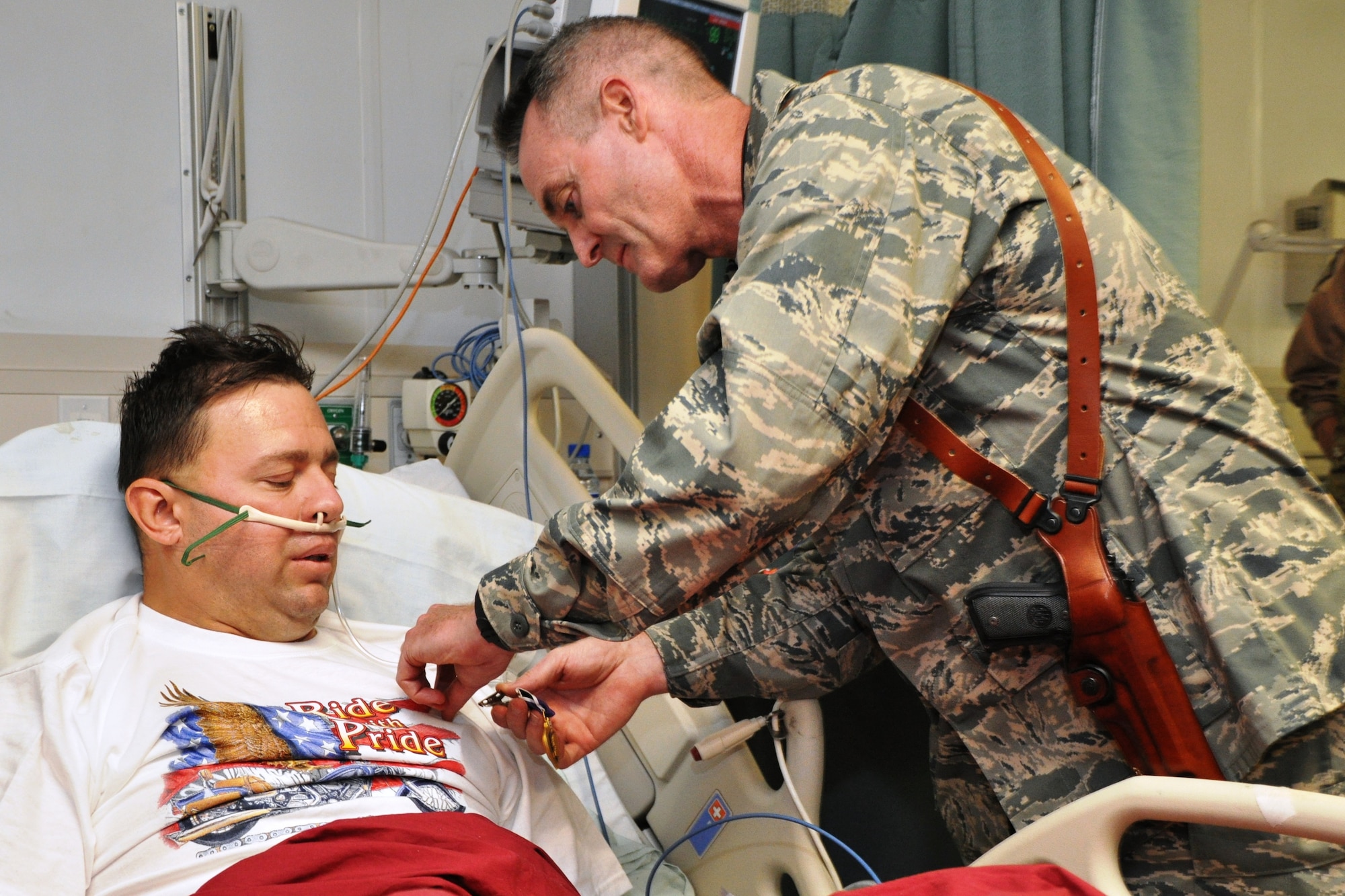 Brig. Gen. Darryl Roberson, 455th Air Expeditionary Wing commander, pins a Purple Heart Medal on Tech. Sgt. James Davis, 83rd Expeditionary Rescue Squadron, at the Craig Joint Theater Hospital, April 23, 2011.  Sergeant Davis was shot in the leg during a mission to recover the pilots of a downed Army helicopter.  (U.S. Air Force photo by Capt. Erick Saks)