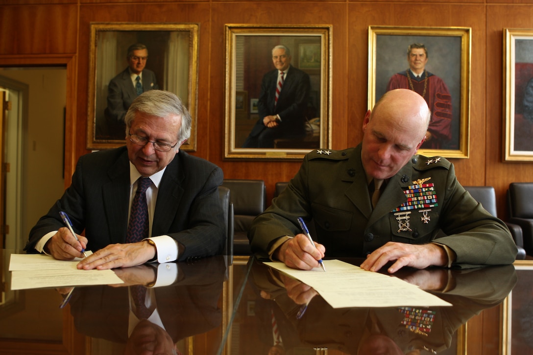 Maj. Gen. Carl Jensen (right), commanding general of Marine Corps Installations – East, signs a memorandum of understanding with Charles Steger, president of the Virginia Polytechnic Institute and State University in Blacksburg, Va., during a visit there in support of the Leadership Scholar Program, an initiative designed in helping veteran Marines and sailors gain easier access into college, May 2.