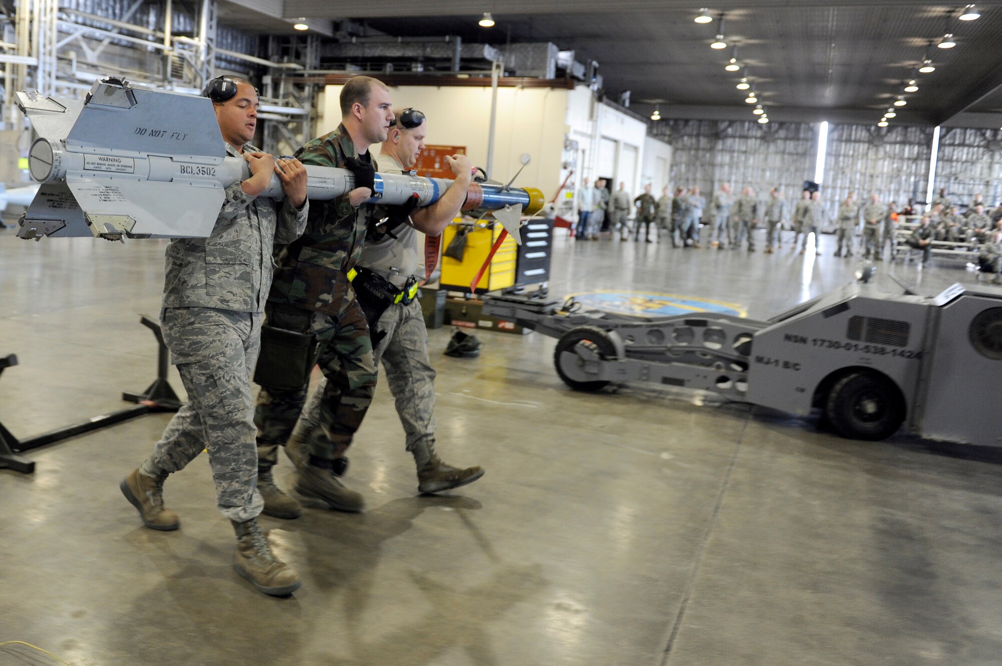 MISAWA AIR BASE, Japan -- Airman 1st Class Robert Flowers-Velasquez, left, Staff Sgt. Mark Drennen, center, and Senior Airman Jacob Wilbanks, 14th Aircraft Maintenance Unit weapons load crew members, move an AIM-9 Sidewinder air-to-air missile April 29. The 14 AMU won the competition with a total of 1,800 points. (U.S. Air Force photo/Staff Sgt. Marie Brown\Released)
