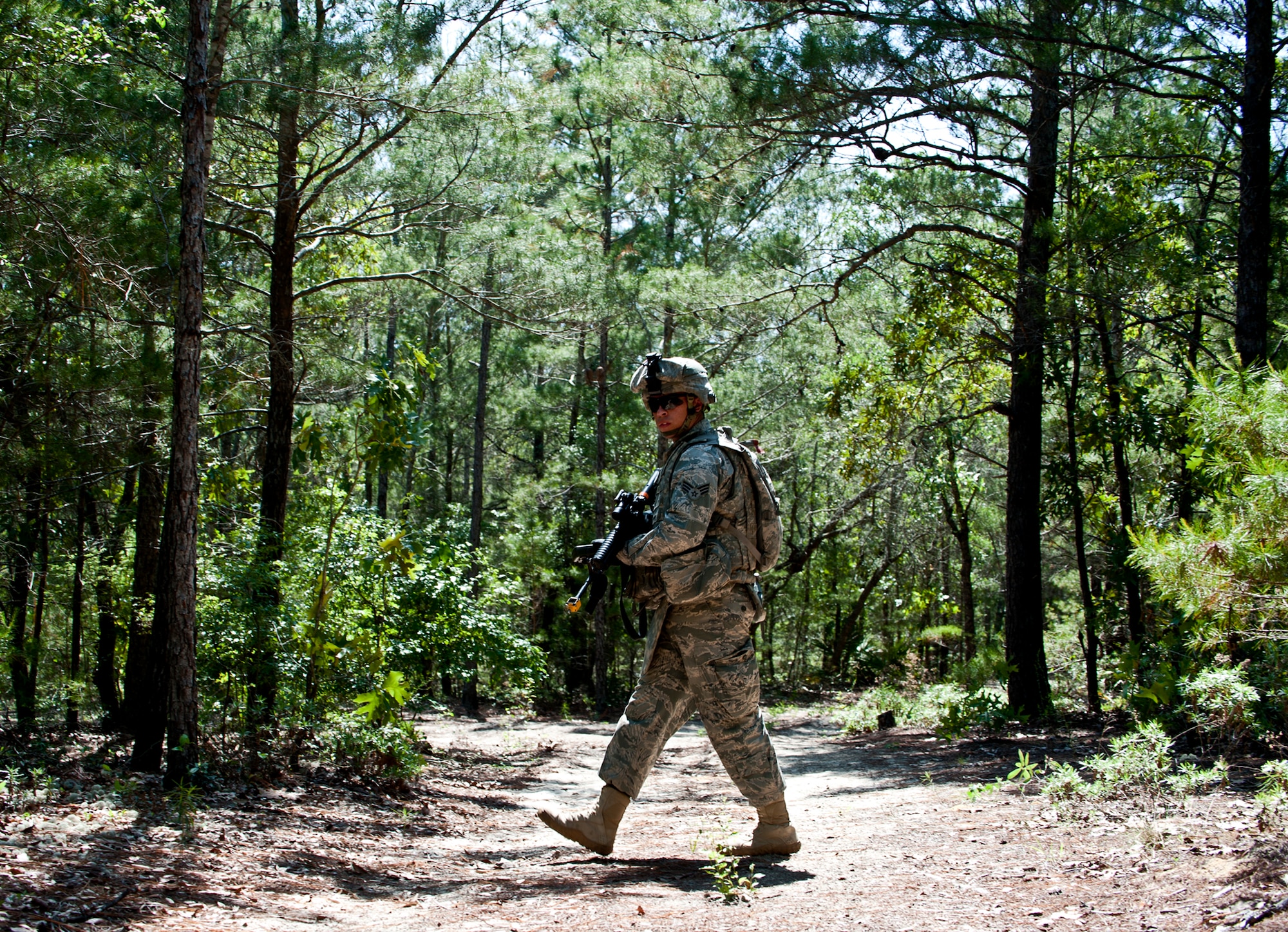 Senior Airman Devin Tiger, 72nd Security Forces Squadron, cautiously crosses a trail in the forest during a scouting mission as part of an exercise April 28 at Eglin Air Force Base, Fla.  This was part of Air Force Materiel Command’s "Brave Defender" training, which is administered by the 96th Ground Combat Training Squadron.   The goal for their exercise was to use land navigation techniques to find a weapons cache based on the intelligence they were given.  GCTS instructors push 10 training classes a year, which consists of improvised explosive device detection and reaction, operating in an urban environment, mission planning, land navigation and casualty care. The three-week training culminates with a three-day field training exercise where the Airmen apply what they learned in combat scenarios.  More than 140 Airmen from more than 10 locations attended this training.  (U.S. Air Force photo/Samuel King Jr.)