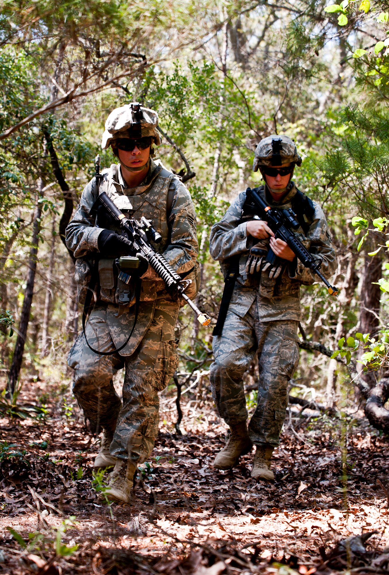 Senior Airman Devin Tiger, 72nd Security Forces Squadron, and Airman 1st Class Guess, 569th U.S. Forces Police, move as a scouting team through the forest during an ‘outside the wire’ exercise April 28 at Eglin Air Force Base, Fla.  This was part of Air Force Materiel Command’s "Brave Defender" training, which is administered by the 96th Ground Combat Training Squadron.   The goal for their exercise was to use land navigation techniques to find a weapons cache based on the intelligence they were given.  GCTS instructors push 10 training classes a year, which consists of improvised explosive device detection and reaction, operating in an urban environment, mission planning, land navigation and casualty care.   The three-week training culminates with a three-day field training exercise where the Airmen apply what they learned in combat scenarios.  More than 140 Airmen from more than 12 locations attended this training.  (U.S. Air Force photo/Samuel King Jr.)