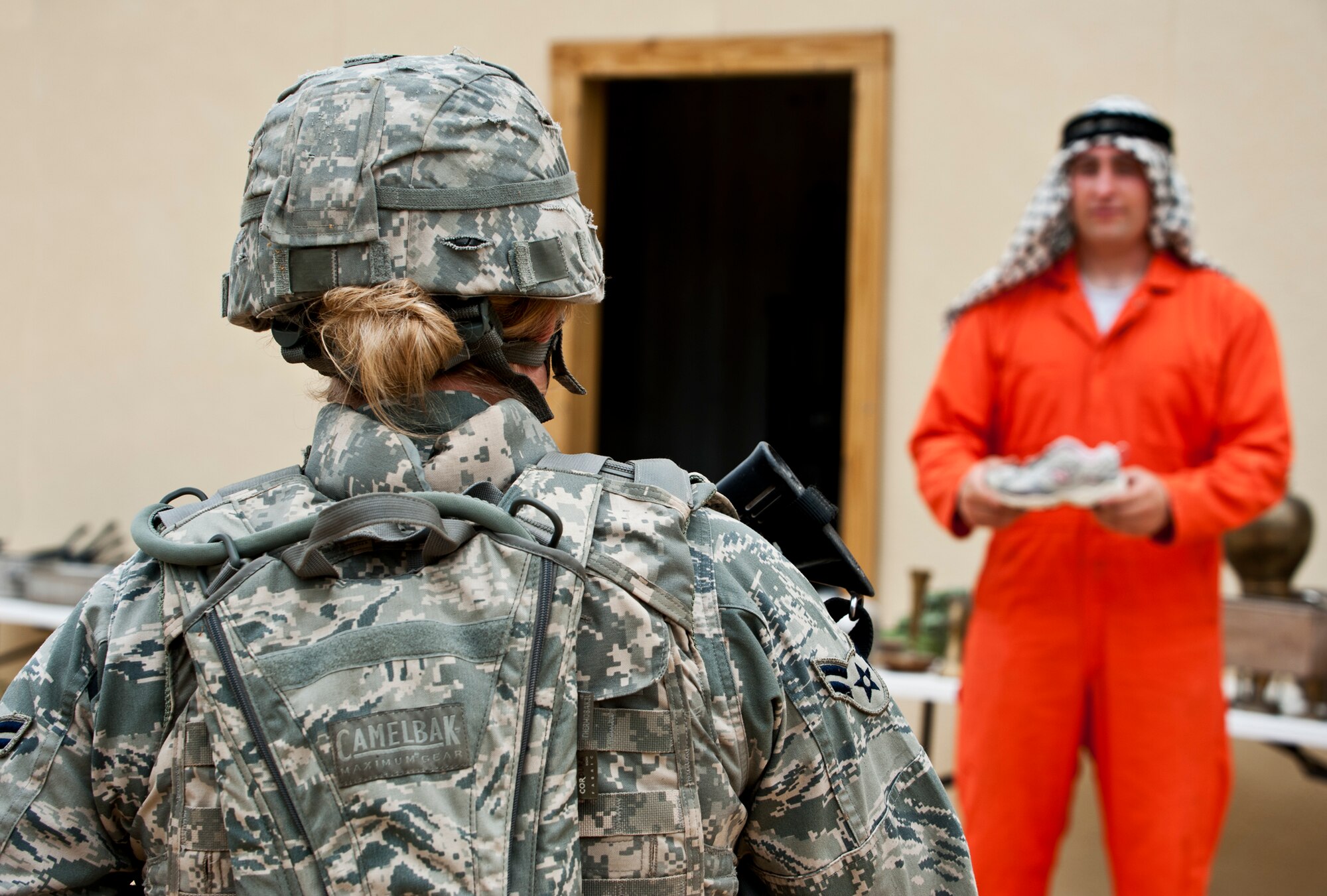 A villager offers his wares to a security forces Airman on a simulated counter-insurgency mission April 27 at Eglin Air Force Base, Fla.  Squads of security forces Airmen were sent into simulated villages to mingle with locals, gather intelligence and familiarize themselves with their surroundings.  This was part of Air Force Materiel Command’s "Brave Defender" training, which is administered by the 96th Ground Combat Training Squadron.  GCTS instructors push 10 training classes a year, which consists of improvised explosive device detection and reaction, operating in an urban environment, mission planning, land navigation and casualty care.  The three-week training culminates with a three-day field training exercise where the Airmen apply what they learned in combat scenarios.  More than 140 Airmen from more than six major commands attended this training.  (U.S. Air Force photo/Samuel King Jr.)
