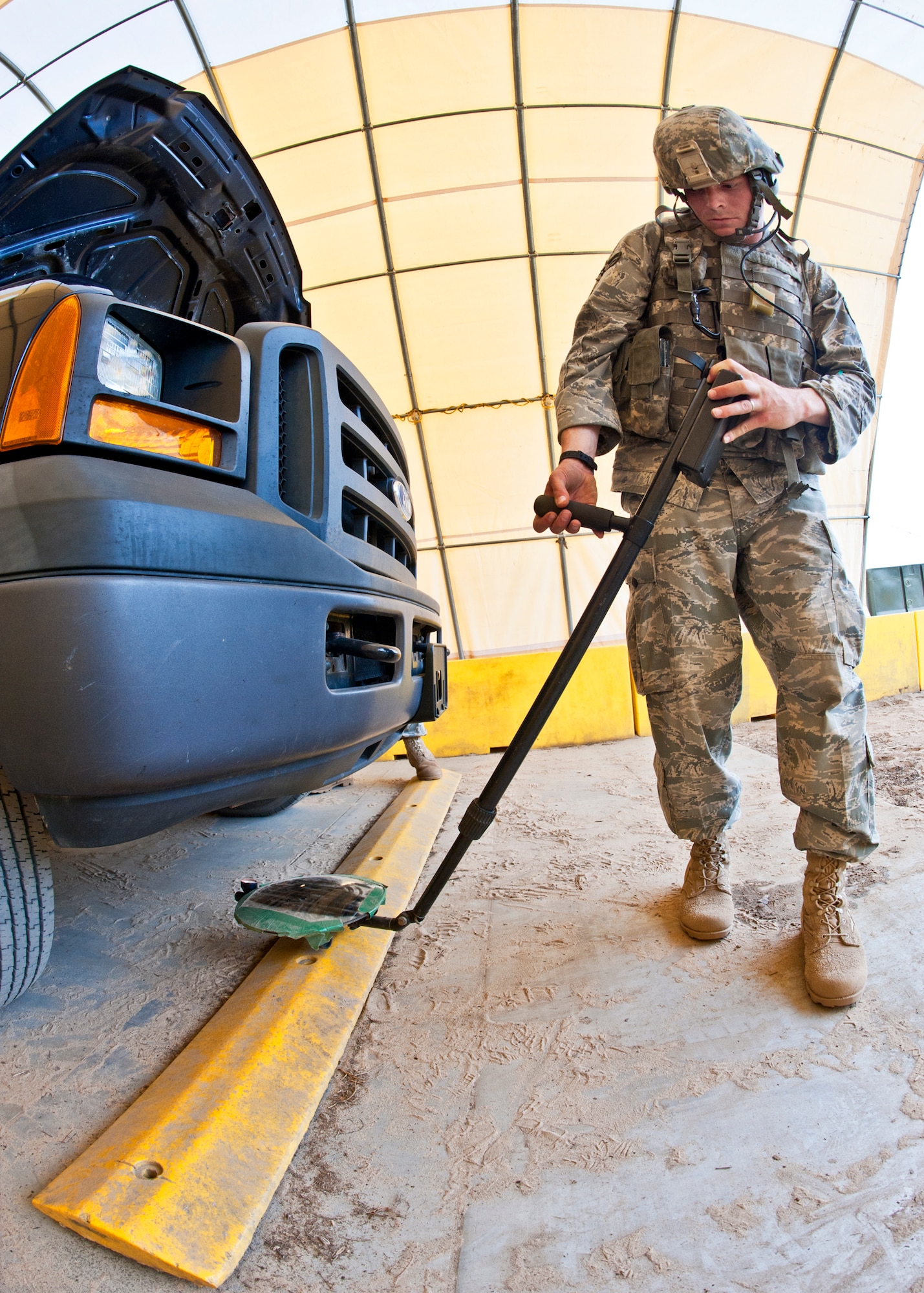 Senior Airman Chris Croft, 82nd Security Forces Squadron, uses a mirror to check underneath a truck during a vehicle inspection at the entry control point during an exercise April 27 at Eglin Air Force Base, Fla.  This was part of Air Force Materiel Command’s "Brave Defender" training, which is administered by the 96th Ground Combat Training Squadron.  ECP guards experienced random vehicle inspections, media visits and vehicle-borne improvised explosive devices during posted shifts.  GCTS instructors push 10 training classes a year, which consists of IED detection and reaction, operating in an urban environment, mission planning, land navigation and casualty care. The three-week training culminates with a three-day field training exercise where the Airmen apply what they learned in combat scenarios.  More than 140 Airmen from more than 12 locations attended this training.  (U.S. Air Force photo/Samuel King Jr.)