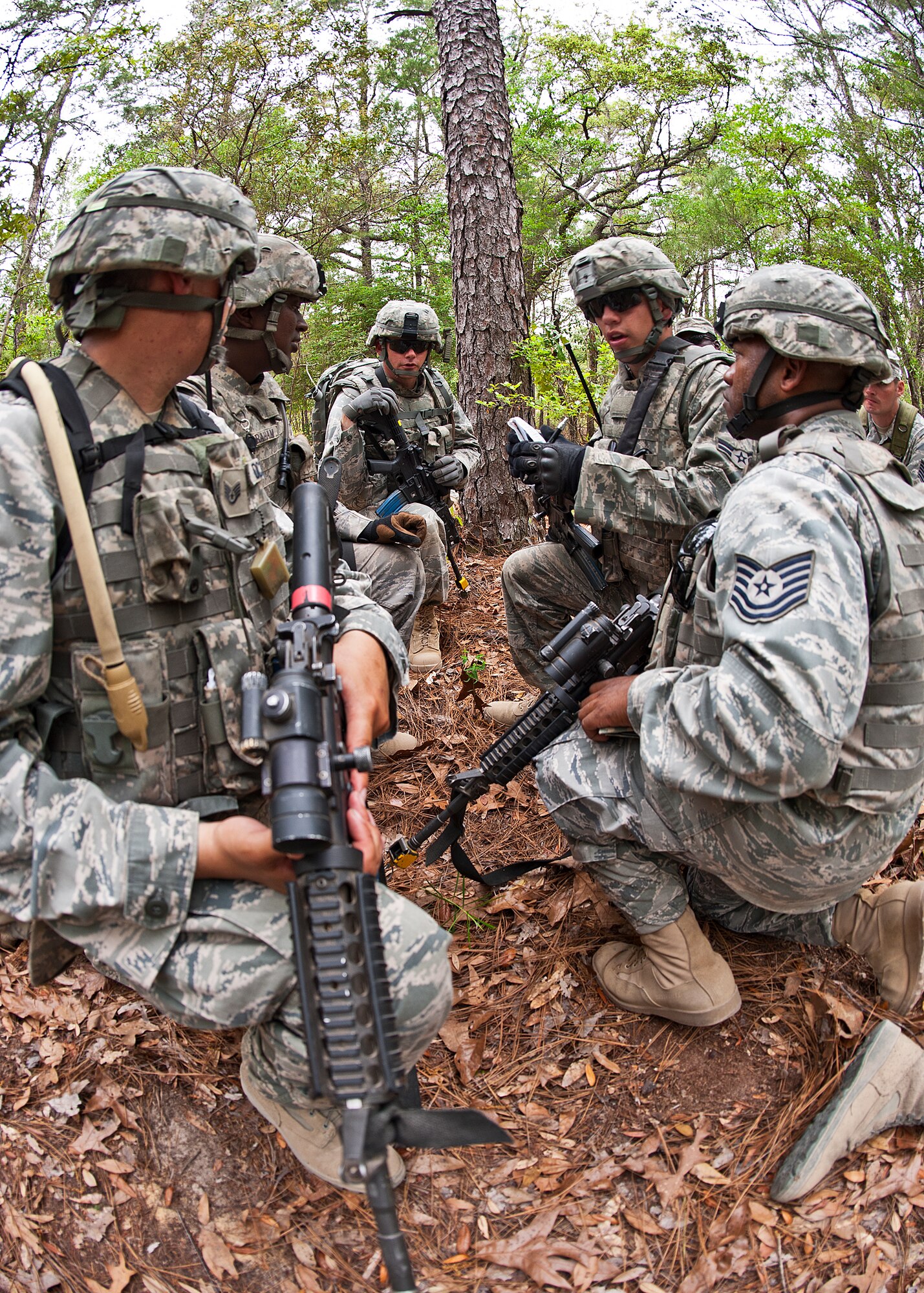 Airmen pass along intelligence gathered from the last simulated counter-insurgency mission to their squad leader April 27 at Eglin Air Force Base, Fla.  This was part of Air Force Materiel Command’s "Brave Defender" training, which is administered by the 96th Ground Combat Training Squadron.  GCTS instructors push 10 training classes a year, which consists of improvised explosive device detection and reaction, operating in an urban environment, mission planning, land navigation and casualty care.  More than 140 Airmen from more than 12 locations attended this training.  (U.S. Air Force photo/Samuel King Jr.)