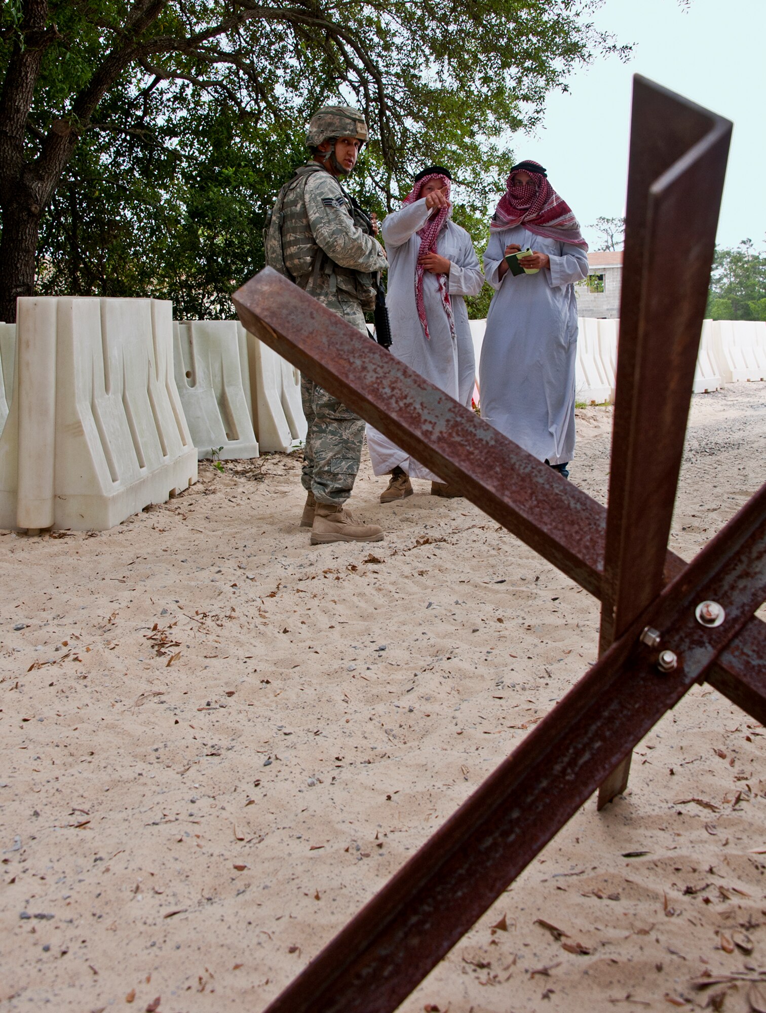 An Airman talks with ‘local media’ from the village during an exercise April 27 at Eglin Air Force Base, Fla.  This was part of Air Force Materiel Command’s "Brave Defender" training, which is administered by the 96th Ground Combat Training Squadron.  GCTS instructors push 10 training classes a year, which consists of improvised explosive device detection and reaction, operating in an urban environment, mission planning, land navigation and casualty care.  The three-week training culminates with a three-day field training exercise where the Airmen apply what they learned in combat scenarios.  More than 140 Airmen from more than 12 locations attended this training.  (U.S. Air Force photo/Samuel King Jr.)