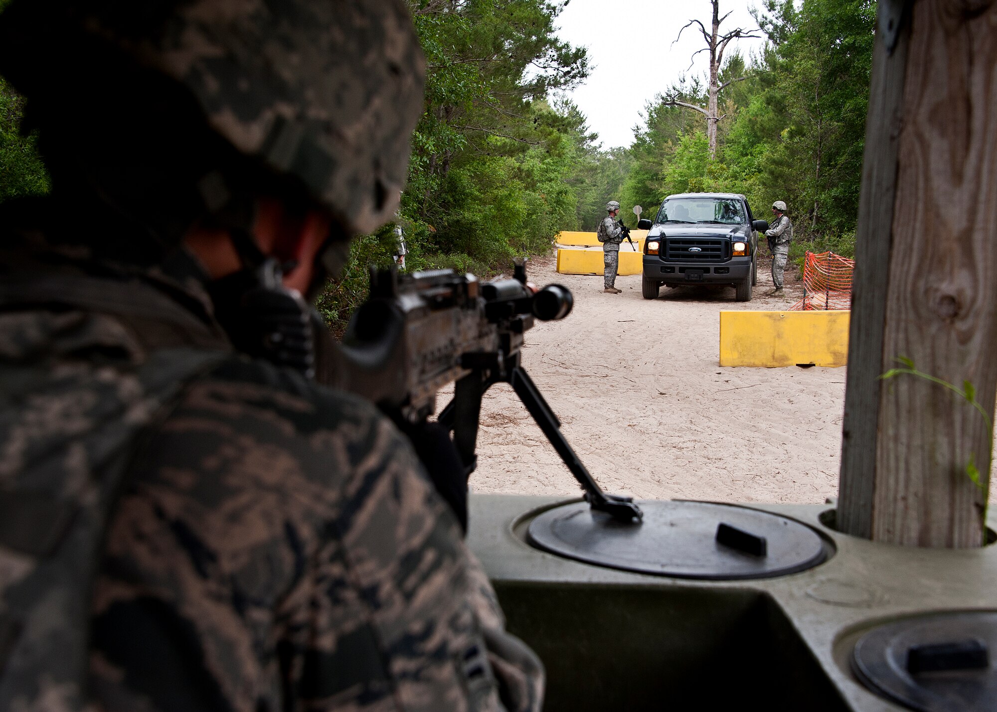 An Airman aims his M249 at the vehicle trying to enter the entry control point during an exercise April 27 at Eglin Air Force Base, Fla.  This was part of Air Force Materiel Command’s "Brave Defender" training, which is administered by the 96th Ground Combat Training Squadron.  ECP guards experienced random vehicle inspections, media visits and vehicle-borne improvised explosive devices  during posted shifts.   GCTS instructors push 10 training classes a year, which consists of IED detection and reaction, operating in an urban environment, mission planning, land navigation and casualty care. The three-week training culminates with a three-day field training exercise where the Airmen apply what they learned in combat scenarios.  More than 140 Airmen from more than 12 locations attended this training.  (U.S. Air Force photo/Samuel King Jr.)
