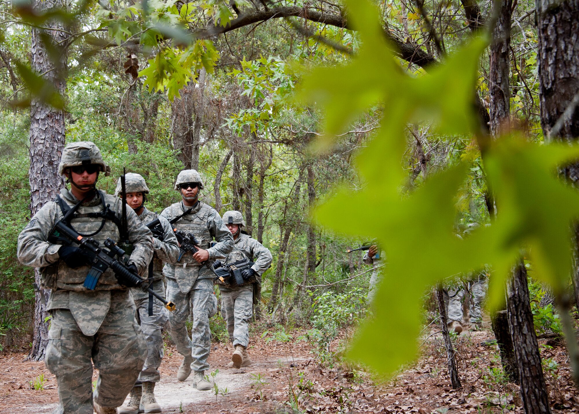 A squad of security forces Airmen patrol the forests ‘outside the wire’ during simulated mission April 27 at Eglin Air Force Base, Fla.  This was part of Air Force Materiel Command’s Brave Defender training, which is administered by the 96th Ground Combat Training Squadron.  GCTS instructors push 10 training classes a year, which consists of improvised explosive device detection and reaction, operating in an urban environment, mission planning, land navigation and casualty care.  More than 140 Airmen from more than six major commands attended this training.  (U.S. Air Force photo/Samuel King Jr.)