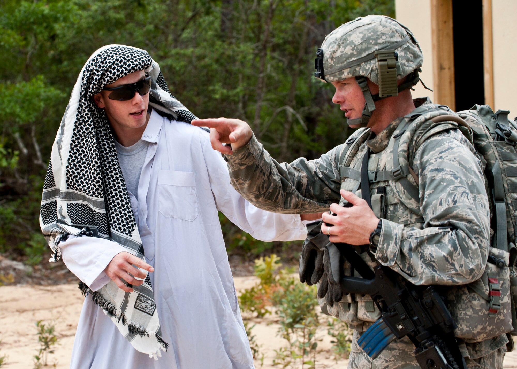 Maj. Justin Oldt, 99th Mission Support Group, talks with a ‘local villager’ during a simulated counter-insurgency mission April 27 at Eglin Air Force Base, Fla.  Squads of security forces Airmen were sent into simulated villages to mingle with locals, gather intelligence and familiarize themselves with their surroundings.  This was part of Air Force Materiel Command’s "Brave Defender" training, which is administered by the 96th Ground Combat Training Squadron.  GCTS instructors push 10 training classes a year, which consists of improvised explosive device detection and reaction, operating in an urban environment, mission planning, land navigation and casualty care.  More than 140 Airmen from more than six major commands attended this training.  (U.S. Air Force photo/Samuel King Jr.)