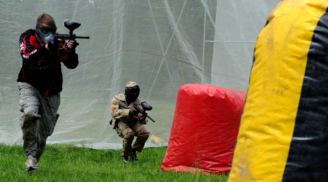 Staff Sgt. Brandon Jewell, 11th Civil Engineer Squadron engineering assistant, and Airman 1st Class Marques Hobbs, 11 CES engineering apprentice run to take cover during the Paintball Season Opener hosted by Outdoor Recreation April 29 at the paintball field. The event had free play, food, and prizes the participants.  (U.S. Air Force Photo/ Airman 1st Class Bahja J. Jones) 