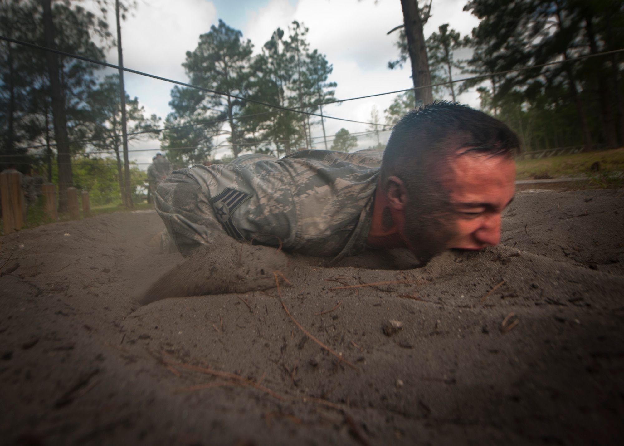 CAMP BLANDING, Fla.-- Staff Sgt. Jonathan Smith, 820th  Communication Operations Squadron NCO in charge of training, gets a mouthful of dirt while low crawling through sand April 27. Every Airman was encouraged to complete each station to their full ability while getting words of motivation at every station. (U.S. Air Force photo/Airman 1st Class Joshua Green)(RELEASED)
