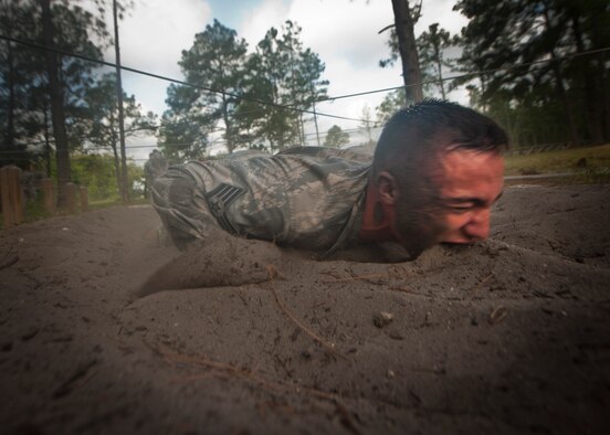 CAMP BLANDING, Fla.-- Staff Sgt. Jonathan Smith, 820th Combat Operations Squadron NCO in charge of training, gets a mouthful of dirt while low crawling through sand April 27. Every Airman was encouraged to complete each station to their full ability while getting words of motivation at every station. (U.S. Air Force photo/Airman 1st Class Joshua Green)(RELEASED) 