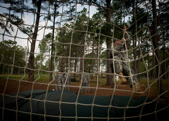 CAMP BLANDING, Fla.-- An Airman from the 820th Base Defense Group climbs down a net to finish an obstacle course station April 27. At the station, Airmen were tasked to climb up a 15 ft. rope, walk across wide beams, climb up a wooden ladder and make their way down to finish the station. (U.S. Air Force photo/Airman 1st Class Joshua Green)(RELEASED)
