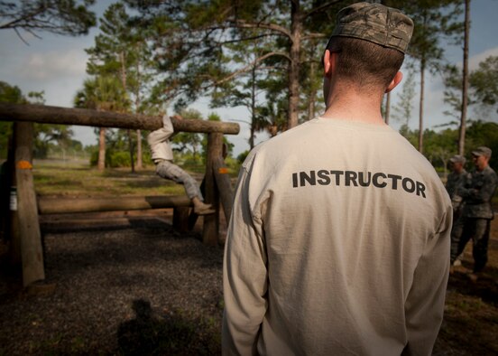 CAMP BLANDING, Fla.-- Tech. Sgt. Garret Brown, 820th Base Defense Group NCO in charge of training, observes as another instructor demonstrates proper techniques at an obstacle course station April 27. There were a total of nine stations to be completed on the course, and each Airman was given two attempts to complete each station’s task. (U.S. Air Force photo/Airman 1st Class Joshua Green)(RELEASED)
