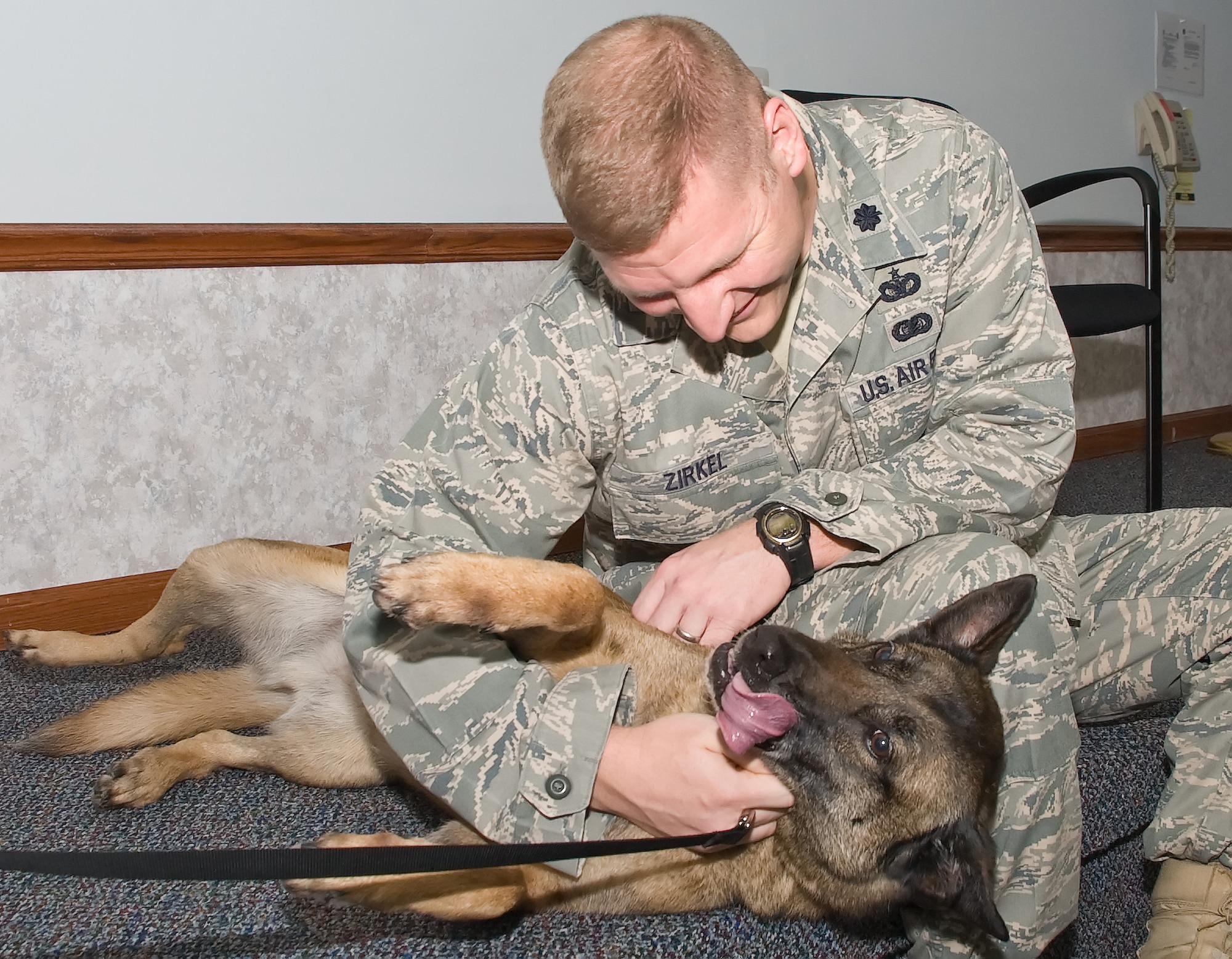 Lt. Col. James Zirkel, 436th Security Forces Squadron commander, pets Military Working Dog Loeka at her retirement ceremony April 28, 2011, at Dover Air Force Base, Del.  Loeka is one of the many military working dogs that the 436 SFS employs to keep Dover AFB safe from explosives, narcotics and other threats. (U.S. Air Force photo by Adrian Rowan)   