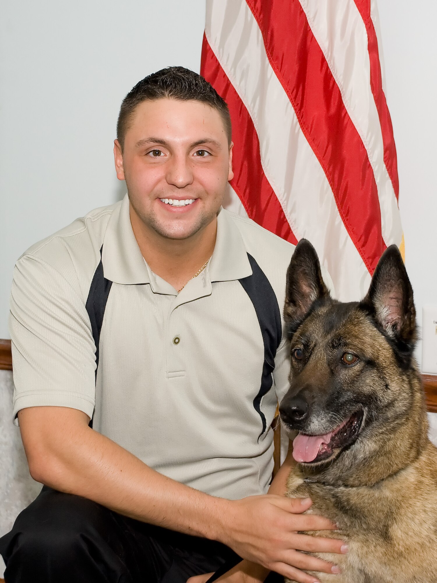 Military Working Dog Loeka and her former handler, John Leonard, pose for a photo at Loeka’s retirement ceremony April 28, 2011, at Dover Air Force Base, Del. Mr. Leonard will be adopting Loeka following her transition to civilian life. (U.S. Air Force photo by Adrian Rowan)   