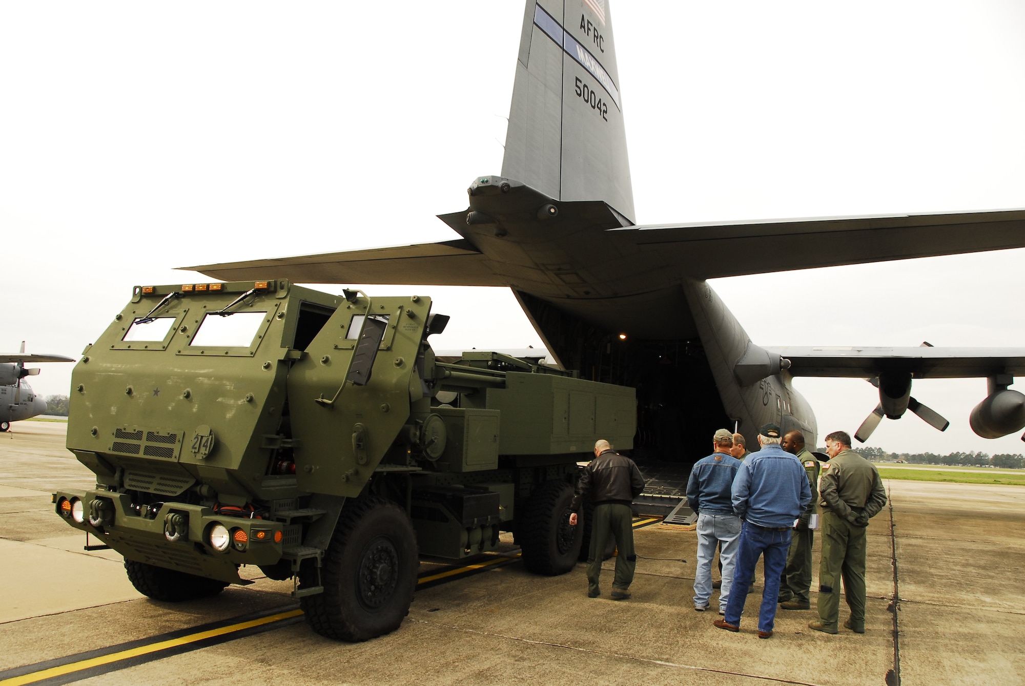 The 908th Airlift Wing recently teamed with the U.S. Army and Lockheed Martin to help increase transport capabilities involving a High Mobility Artillery Rocket System (HIMARS, an artillery rocket platform mounted on a five-ton truck. Above, 908th crew members line up the HIMARS prior to loading it on a C-130. 