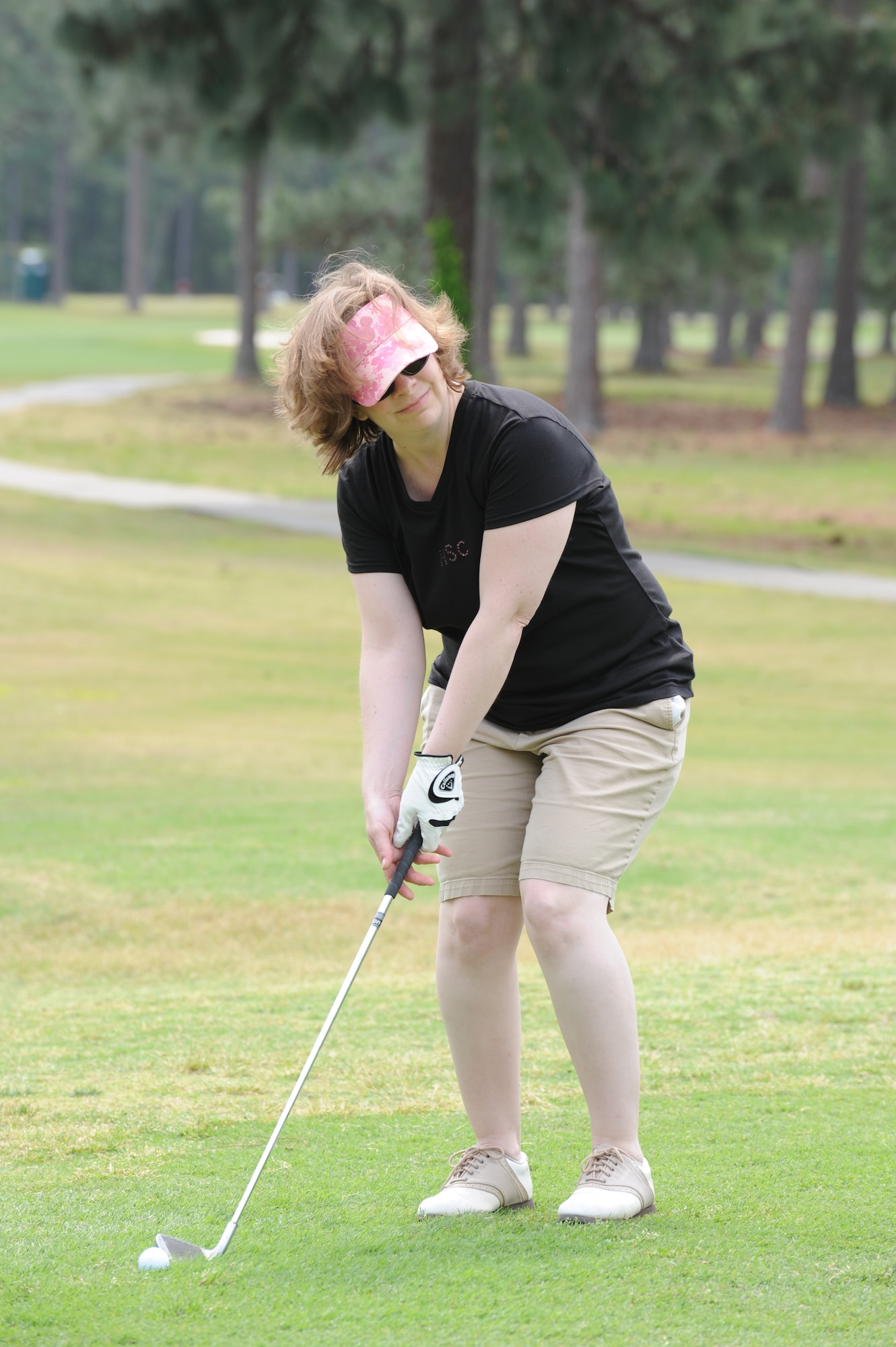 Theresa Kossler, Hurlburt Field Spouses' Club member, focuses on putting the ball in the hole before swinging at the 4th Annual Golf Scramble at Gator Lakes Golf Course on Hurlburt Field, Fla., April 15, 2011. The scramble was hosted by the HSC to raise money for charity. (DOD photo by Airman 1st Class Caitlin O'Neil McKeown/RELEASED) 