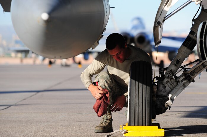 NELLIS AIR FORCE BASE, Nev. -- Airman 1st Class Alex Lenz, a crew chief from the 20th Aircraft Maintenance Unit, Shaw Air Force Base, S.C., cleans the wheels on an F-16D Fighting Falcon during Green Flag West 11-6, April 28.  Green Flag West replicates irregular warfare conditions currently found in Southwest Asia. Aircrews, work closely with Air Force joint terminal attack controllers. Pilots train for a missions such as close air support, and aerial reconnaissance.  (U.S. Air Force photo by Staff Sgt. William P.Coleman)  