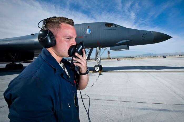 NELLIS AIR FORCE BASE, Nev. --  Airman 1st Class Joseph Dowdell, a crew chief from the 28th Aircraft Maintenance Squadron, Ellsworth AFB, S.D., communicates with B-1 Lancer pilots via headset during exercise Green Flag West 11-6, April 28. Green Flag West replicates irregular warfare conditions currently found in Southwest Asia. Aircrews, work closely with Air Force joint terminal attack controllers. Pilots train for a missions such as close air support, and aerial reconnaissance.(U.S. Air Force photo by Senior Airman Brett Clashman)