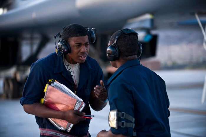 NELLIS AIR FORCE BASE, Nev. --  Senior Airman Quincee Baker and Airman 1st Class Samuel Carr, crew chiefs from the 28th Aircraft Maintenance Squadron, Ellsworth AFB, S.D., discuss preflight procedures before marshalling a B-1B Lancer during exercise Green Flag West 11-6, April 28. Green Flag West replicates irregular warfare conditions currently found in Southwest Asia. Aircrews, work closely with Air Force joint terminal attack controllers. Pilots train for a missions such as close air support, and aerial reconnaissance.(U.S. Air Force photo by Senior Airman Brett Clashman)