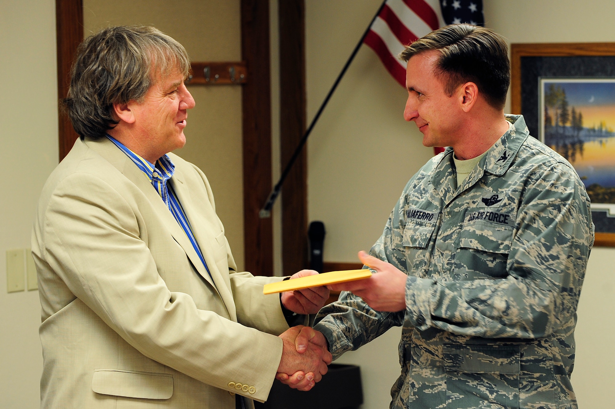(Right) Col. Jeffrey Taliaferro, 28th Bomb Wing commander, presents the deed to the 53.32 acres of land formerly used for military housing to Mark Merchen, South Dakota Ellsworth Development Authority executive director, during a special event in Box Elder, S.D., April 29, 2011.   The land, first purchased by the government in 1957, served families at Ellsworth until the early 1990’s. (U.S. Air Force photo/Staff Sgt. Marc I. Lane)