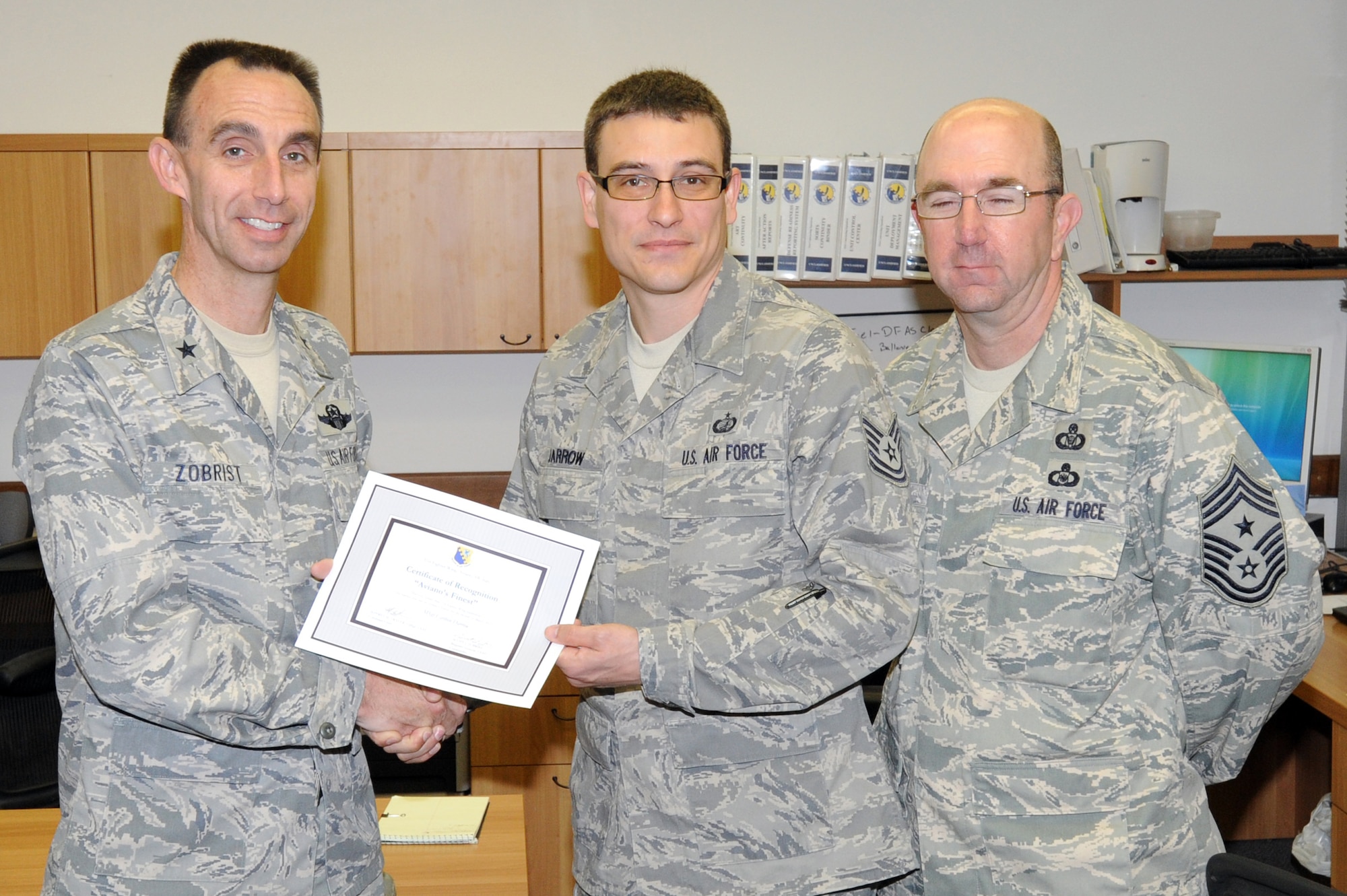 Brig. Gen. Scott J. Zobrist, 31st Fighter Wing commander, and Chief Master Sgt. Jeffrey Craver, 31st FW command chief, congratulate Tech. Sgt. Carlton Darrow, 31st Contracting Squadron Base Acquisitions Flight NCO in charge, on his selection as one of Aviano's Finest April 29. (U.S. Air Force photo/Airman 1st Class LaVel Sterling)