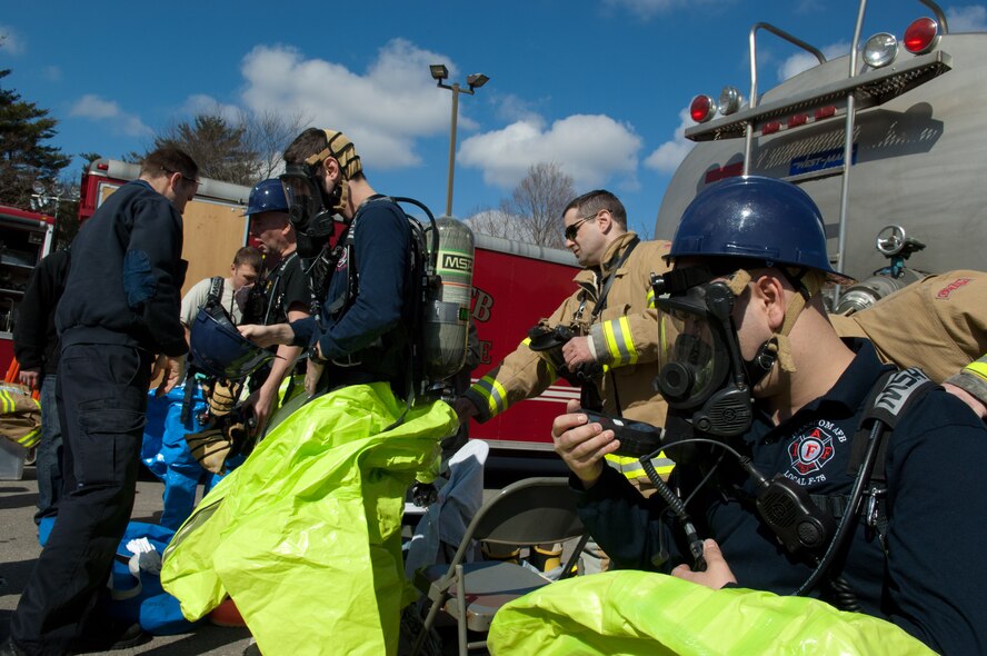 Members of the Hanscom Fire Department put on their protective gear as they prepare to respond to an emergency during a base readiness exercise March 15.  Hanscom held comprehensive, week-long exercises in  both March and April, which have helped the base improve its readiness posture.  (U.S. Air Force photo by Rick Berry)