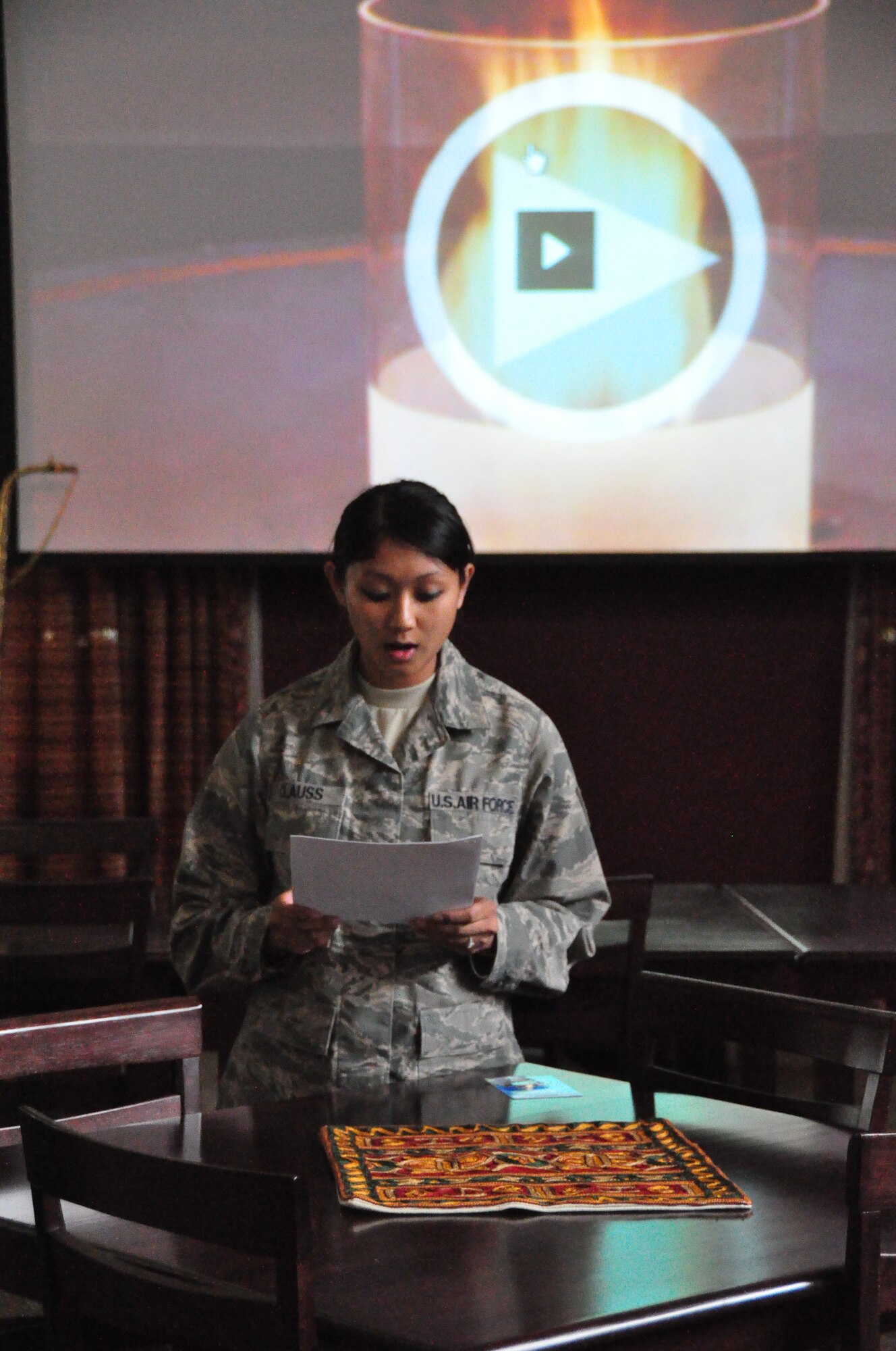 Staff Sgt. Rene Clauss recites her award-winning essay during the Holocaust Day of Remembrance ceremony May 1, at an undisclosed location in Southwest Asia.  During the ceremony, deployed military members watched a video and heard remarks about the dangers of apathy in the face of others’ suffering.  Sergeant Clauss is deployed from McConnell AFB, Kan. and is assigned to the (U.S. Air Force photo/Master Sgt. Michael Hammond)      
