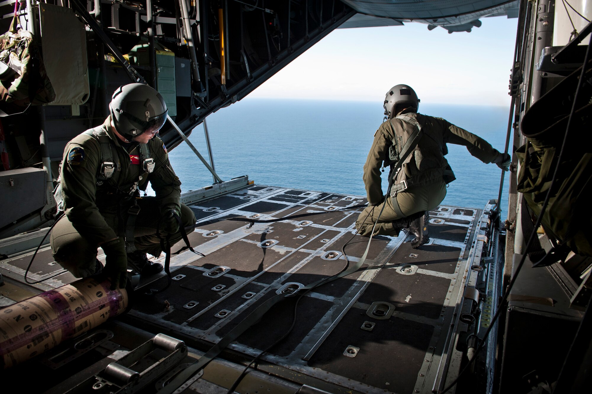 PACIFIC OCEAN -- Staff Sgt. Blake Landry (left) 36th Airlift Squadron loadmaster, and Lt. Col. Dave Kincaid, 374th Operations Group deputy commander, wait for the signal to deploy a Davis Drifter Buoy from a C-130 Hercules off the eastern coast of Japan, April 29, 2011. The C-130 crew dropped seven buoys off the eastern coast of Japan to help Japanese and American scientists monitor ocean currents. (U.S. Air Force photo/Staff Sgt. Samuel Morse)