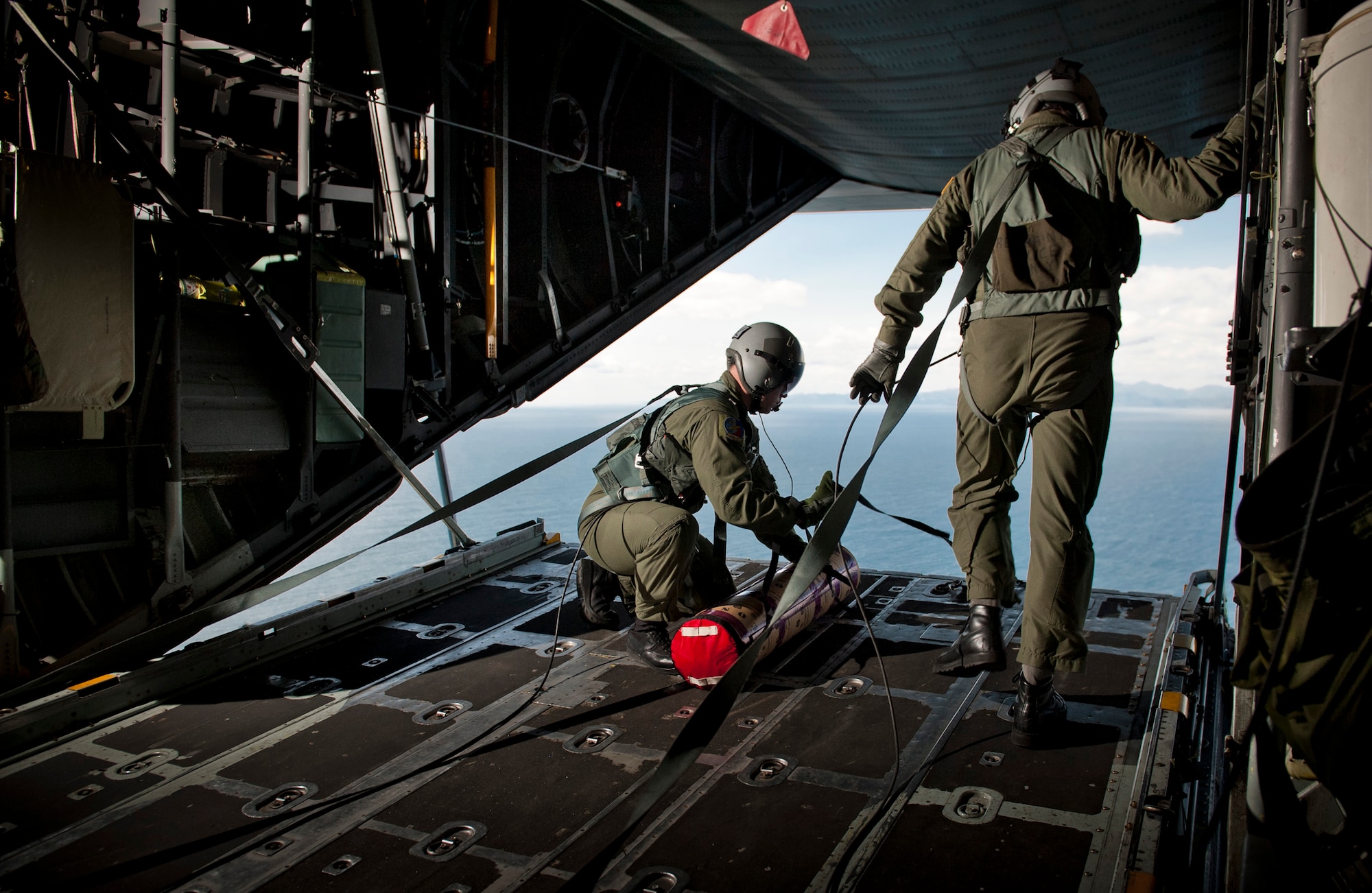 PACIFIC OCEAN -- Staff Sgt. Blake Landry (left) and Senior Master Sgt. Chris Walker, 36th Airlift Squadron loadmasters, prepare to deploy a Davis Drifter Buoy from a C-130 Hercules off the eastern coast of Japan, April 29, 2011. The C-130 crew dropped seven buoys off the eastern coast of Japan to help Japanese and American scientists monitor ocean currents. (U.S. Air Force photo/Staff Sgt. Samuel Morse)