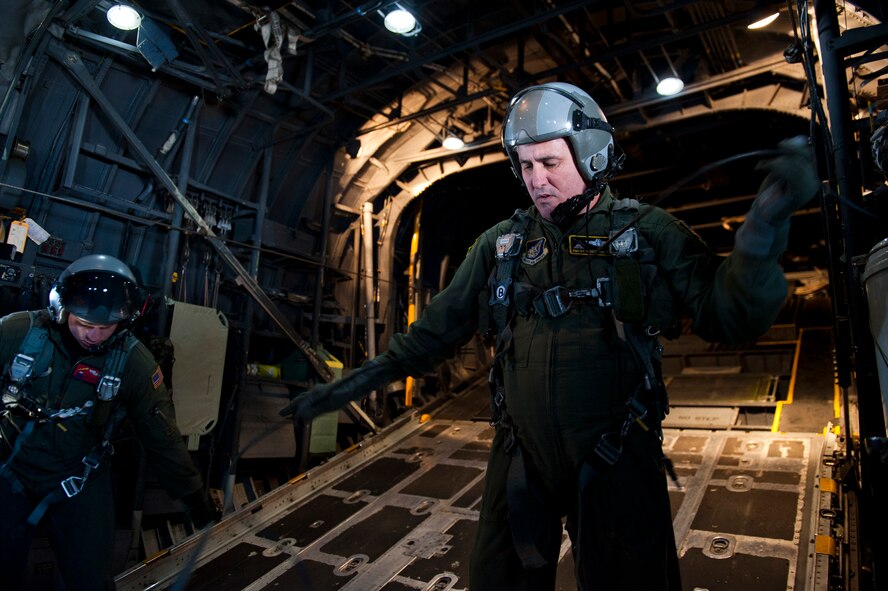 PACIFIC OCEAN -- Senior Master Sgt. Chris Walker, 36th Airlift Squadron loadmaster flight chief, prepares his safety equipment before opening the cargo door on a C-130 Hercules flying over the Pacific Ocean, April 29, 2011. The C-130 crew dropped seven Davis Drifter Buoys off the eastern coast of Japan to help Japanese and American scientists monitor ocean currents. (U.S. Air Force photo/Staff Sgt. Samuel Morse)