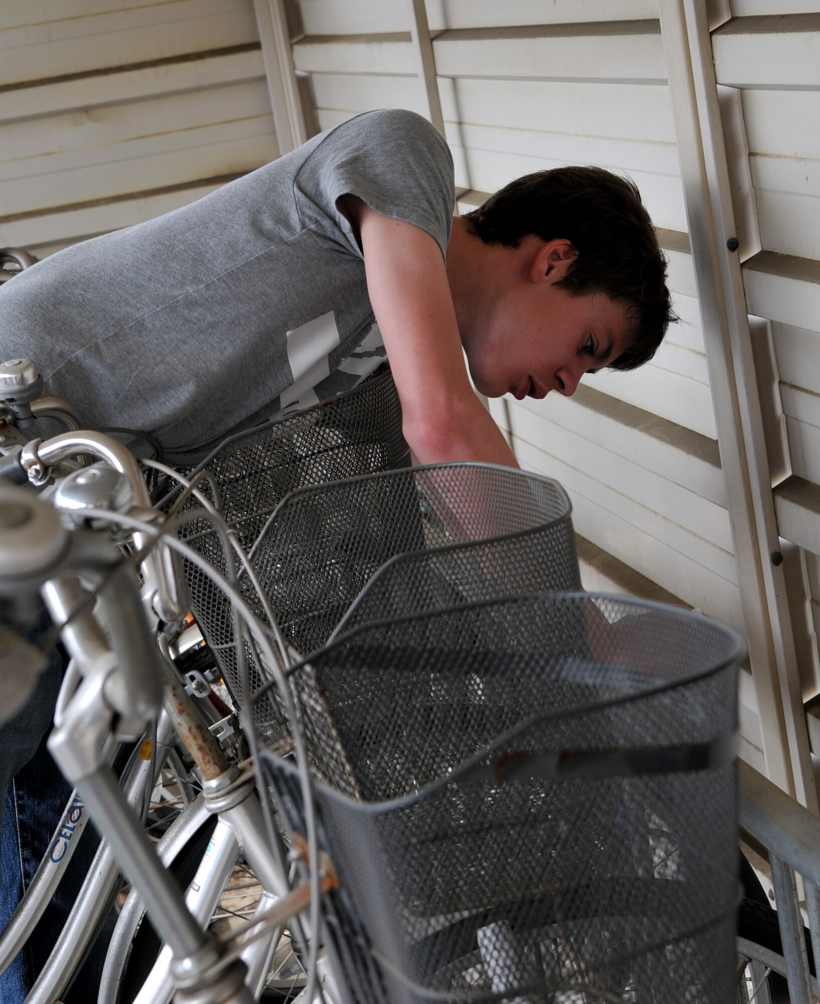 YOKOTA AIR BASE, Japan -- Alex Simkins, National Jr. Honor Society 8th grade student at Yokota Middle School, unlocks bicycles at Yokota Air Base, Japan, April 27, 20011. The bicycles were donated to people affected by the natural disaster in northern Japan. (U.S. Air Force photo/Airman 1st Class Krystal M. Garrett) 