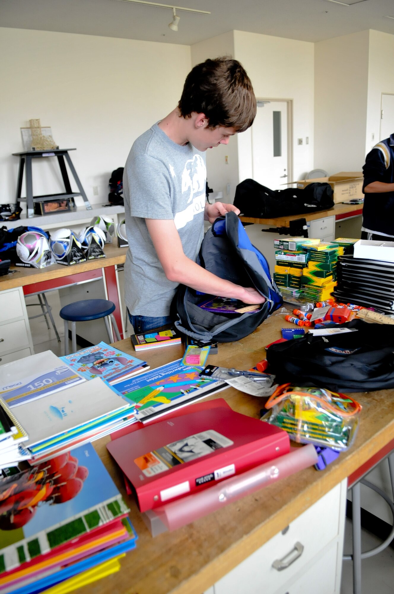 YOKOTA AIR BASE, Japan -- Alex Simkins, a National Jr. Honor Society 8th grade student at Yokota Middle School, places items in a back pack at Yokota Air Base, Japan, April 27, 2011. National Jr. Honor Society students, along with Roots and Shoots students, provided school supplies to Japanese students affected by the natural disaster. (U.S. Air Force photo/Airman 1st Class Krystal M. Garrett) 