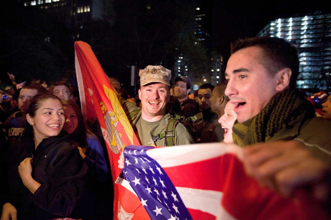 U.S. Marine Corps veterans Mike Demo, center, and Bill Cortese, right, drove 30 minutes to New York's Ground Zero, May 2, 2011, to mark the news of Osama bin Laden's death. Two of Cortese's cousins were killed in the Sept. 11, 2001, attack on the World Trade Center. The Freedom Tower, the skyscraper being built where the World Trade Center towers once stood, is now 60 stories tall and was visible from the street. 