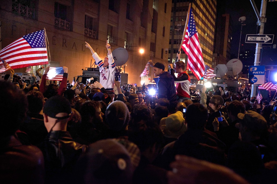 A crowd cheers at the corner of Vesey and Liberty streets next to Ground Zero in New York, May 2, 2011, after hearing news of Osama bin Laden's death. 