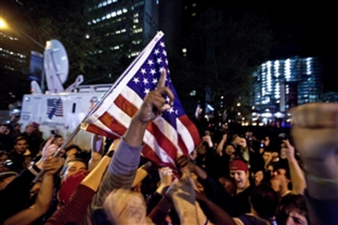 A crowd cheers at the corner of Vesey and Liberty streets next to Ground Zero in New York, May 2, 2011, after hearing the news of Osama bin Laden's death. Bin Laden planned the Sept. 11, 2001, attacks, and has been hunted by American forces in the years since. The Freedom Tower, the skyscraper being built where the World Trade Center towers once stood, is now 60 stories tall and visible from the street.