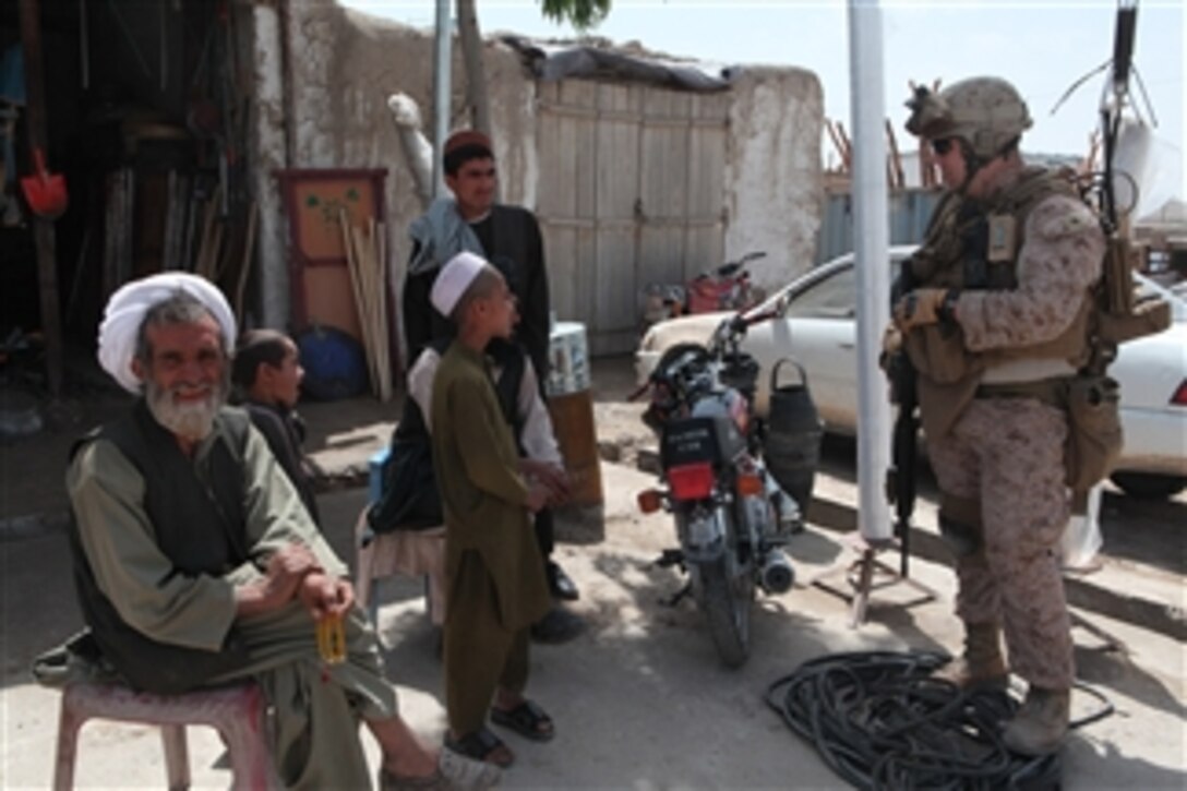 U.S. Marine Corps Lance Cpl. Joshua D. Luke, with 3rd Battalion, 2nd Marine Regiment, Regimental Combat Team 8, speaks to Afghans during a patrol through a bazaar in Musa Qala, Afghanistan, on April 9, 2011.  The battalion patrolled the bazaar to gain the trust of Afghans and establish a presence.  