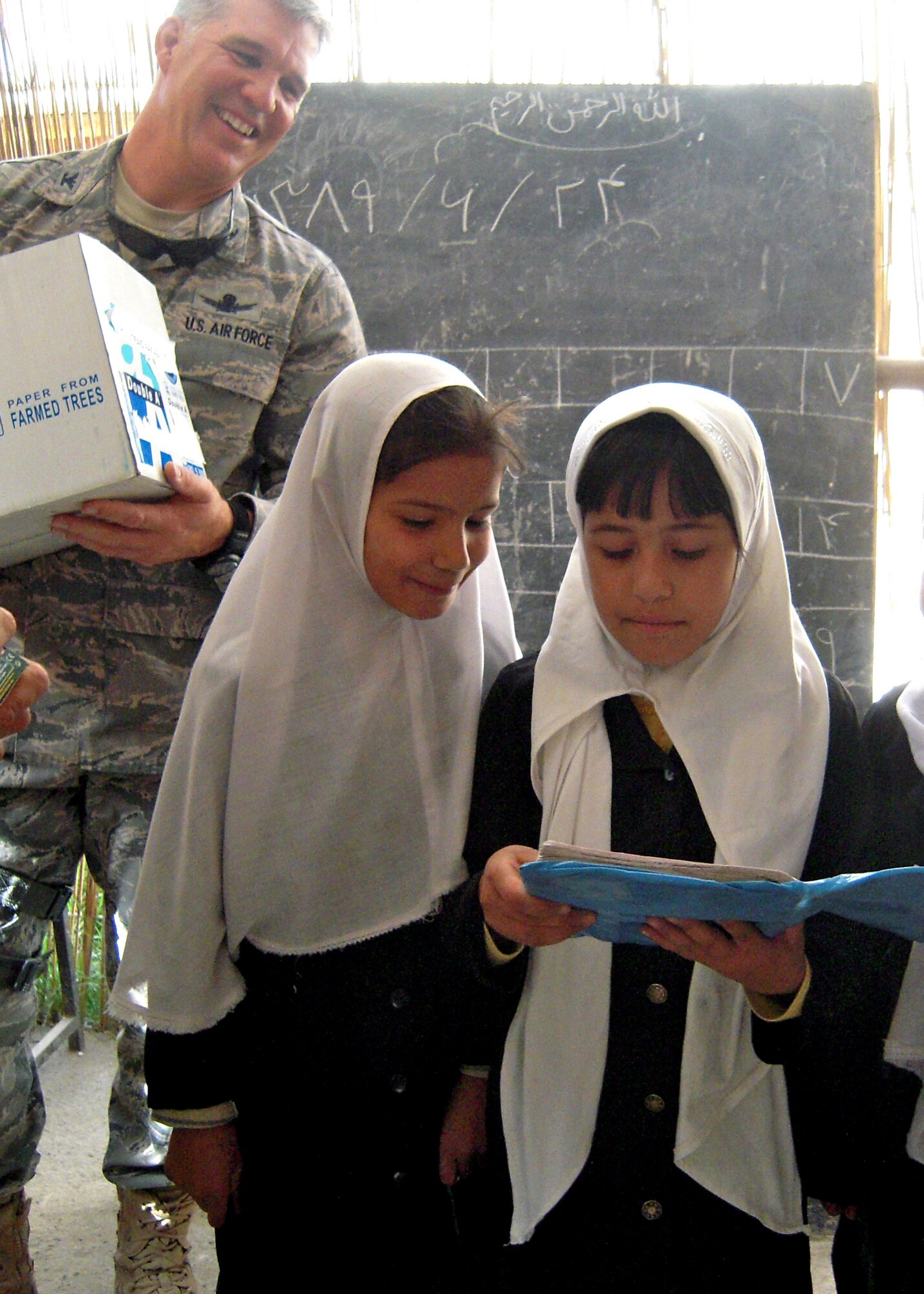 Col. Bob Wicks, Regional Support Command-Capital commander, watches young girls at a school in Kabul, Afghanistan, enjoy school supplies provided by him and other RSC-Capital members during his year-long deployment from the 13th Air Force at Joint Base Pearl Harbor-Hickam, Hawaii. They adopted this girls’ school and donated tents and supplies from care packages sent by family and friends. (Courtesy photo)