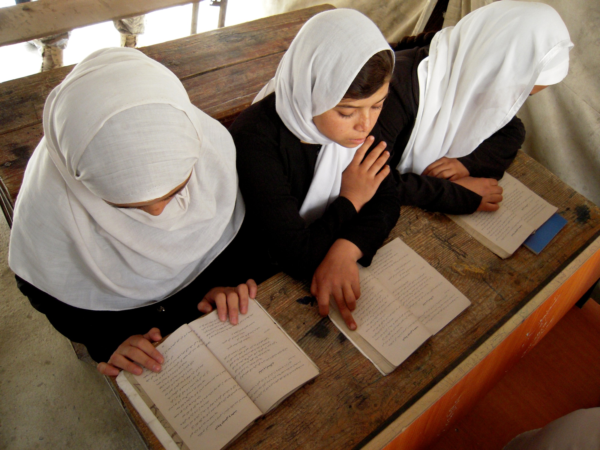 Young girls at a school in Kabul, Afghanistan, study inside a tent provided for them by the military servicemembers at Regional Support Command-Capital, commanded by Col. Bob Wicks from Joint Base Pearl Harbor-Hickam, Hawaii. Colonel Wicks is the only Air Force commander of six Regional Support Commands under the NATO Training Mission-Afghanistan. He returned from Afghanistan for mid-tour leave April 14, after serving eight months of his year-long deployment. (Courtesy photo)