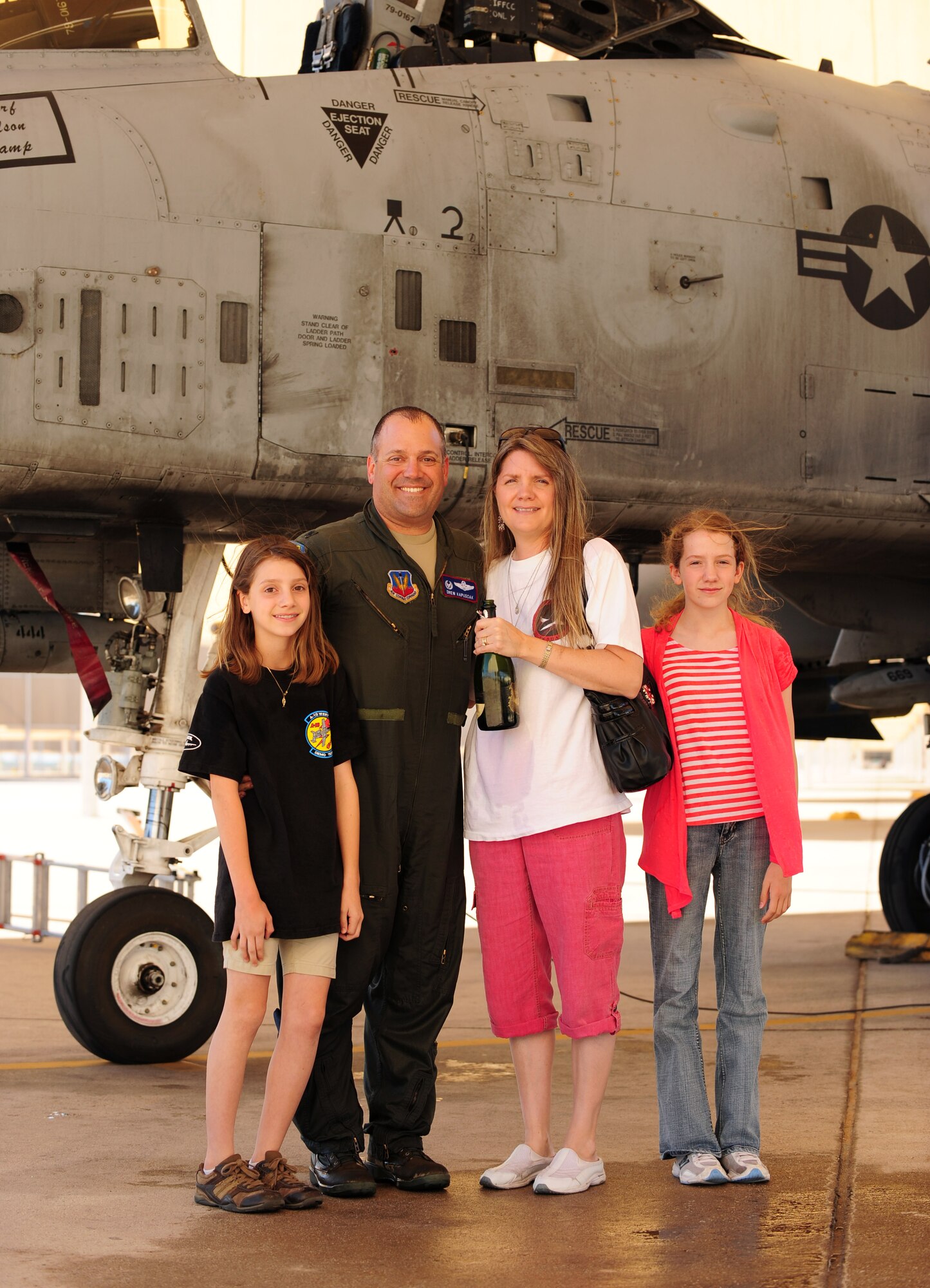 DAVIS-MONTHAN AIR FORCE BASE, Ariz. - Lt. Col. Andrew Kapuscak poses with his family in front of an A-10 aircraft on the flight line here April 27. The colonel’s family greeted him on the flight line on the occasion of reaching his 3,000th flying hour, a milestone in the fighter pilot community. (U.S. Air Force photo/Airman 1st Class Jerilyn Quintanilla)