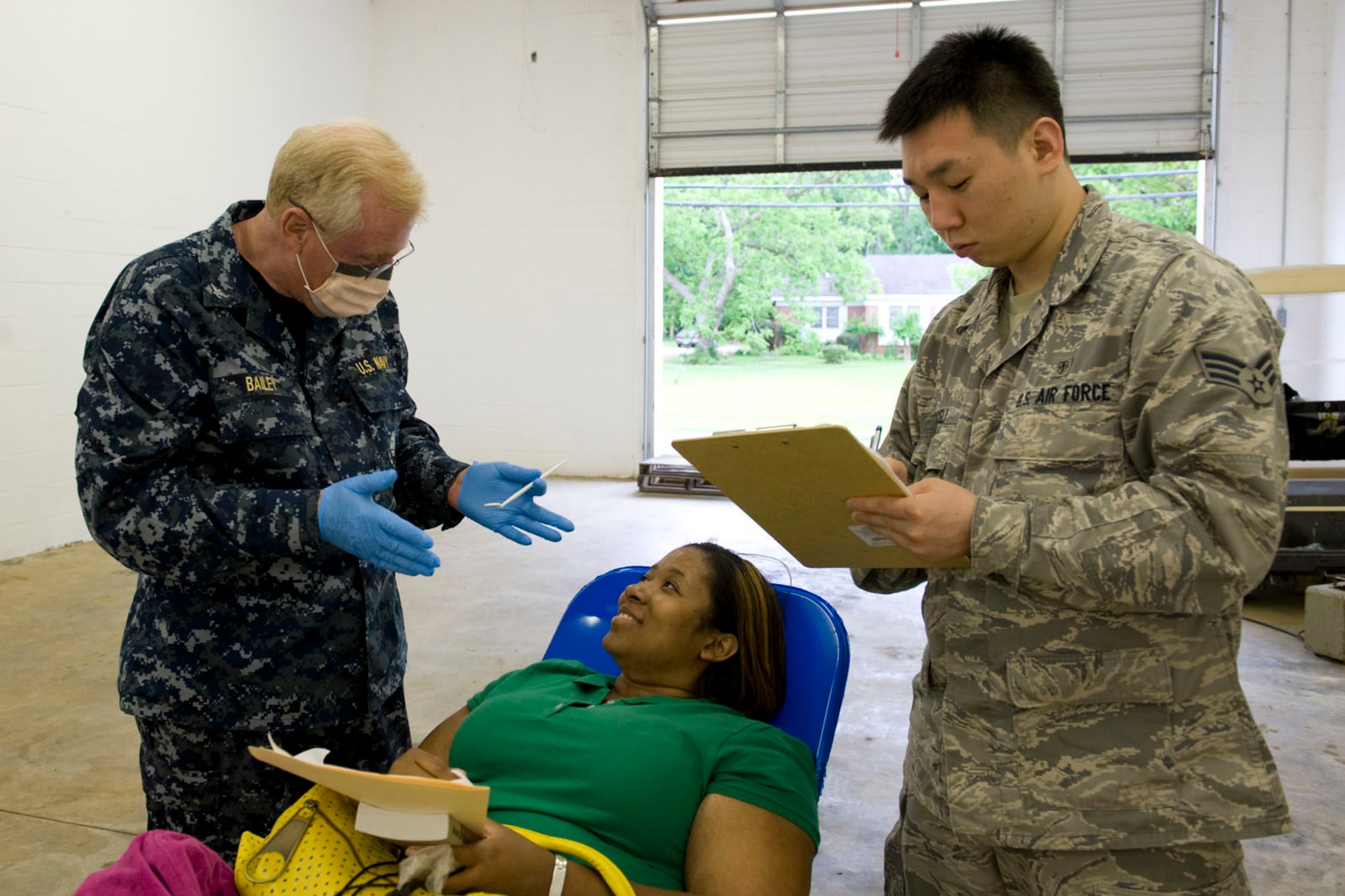 HAYNEVILLE, Ala. - Navy Capt. Stephen Bailey, a dentist, from OHSU, Portsmouth, VA. speaks with a patient on dental care while Senior Airman Daniel Micelli, a dental technician, from the 176th Medical Group, Alaska Air National Guard, takes notes, May 5, 2011.  Bailey and Micelli are in Alabama along with about sixty other medical professional from numerous military components and services for an Innovative Readiness Training (IRT) mission. The IRT program allows for real world training opportunities for military personnel while providing needed services to under-served communities in the United States. Alaska Air National Guard photo by Master Sgt. Shannon Oleson.