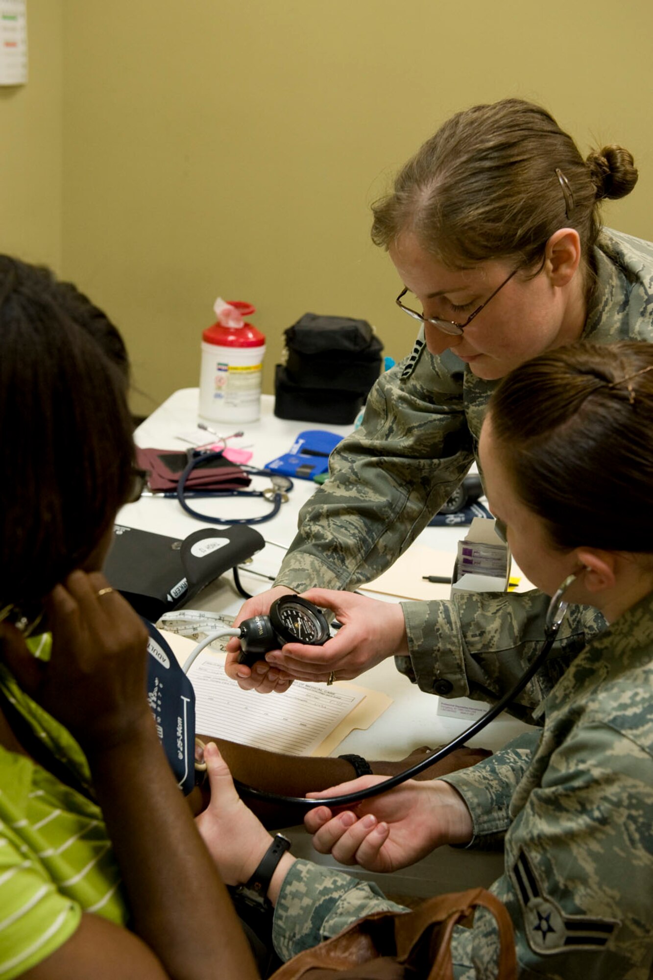 HAYNEVILLE, Ala. - Master Sgt. Jessica Alvarez, a medical service technician, from the 176th Medical Group, Alaska Air National Guard and Airman 1st Class Megan McCarthy, a medical service technician, from the 673d Medical Group, from Joint Base Elmendorf-Richardson, Alaska check a patient?s blood pressure, May 5, 2011. Alvarez and McCarthy are in Alabama along with about sixty other medical professional from numerous military components and services for an Innovative Readiness Training (IRT) mission. The IRT program allows for real world training opportunities for military personnel while providing needed services to under-served communities in the United States. Alaska Air National Guard photo by Master Sgt. Shannon Oleson.