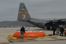 GOWEN FIELD, Idaho -- U.S. Forest Service, California Department of Forestry and Fire Protection and 302nd Air Expeditionary Group personnel load the 3,000 gallon Modular Airborne Fire Fighting System tank with water in preparation for an air drop by a MAFFS-equipped C-130 on a simulated fire. Air Force Reserve and Air National Guard members are currently undergoing their annual currency and re-currency certification required by the U.S. Forest Service prior to this year’s fire season. (U.S. Air Force photo/ Capt. Corinna Jones)