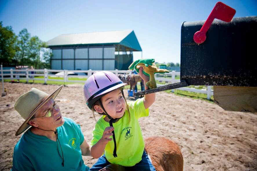 Ansley Dickenson retrieves a toy frog from a mailbox while riding a horse April 30 at Jacobs’ Ladder Therapeutic Riding Center in Hahira, Ga. During the horse rides, children had an opportunity to participate in a series of games, activities and trivia questions geared to stimulate senses of self-esteem, trust and improved social functioning. (U.S. Air Force photo/Staff Sgt. Jamal D. Sutter)(RELEASED)