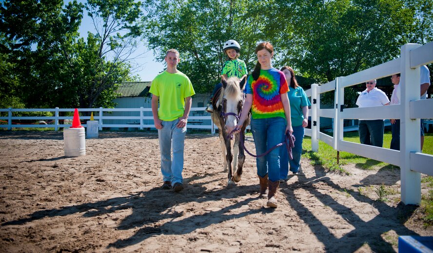 Kyra Hoover, daughter of Tech. Sgt. Jessica Hoover, 23rd Force Support Squadron, receives a horse ride April 30 at Jacobs’ Ladder Therapeutic Riding Center in Hahira, Ga. The riding facility hosted 29 children and their families in part of Moody Air Force Base’s Exceptional Family Member Program. (U.S. Air Force photo/Staff Sgt. Jamal D. Sutter)(RELEASED)