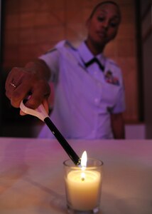 Tech. Sgt. Kenneethia Kennard lights candles during the National Days of Remembrance commemoration ceremony at the Joint Base Charleston Chapel May 2. The ceremony was held to memorialize those who were killed during the Holocaust, to promote human dignity and to confront hate anytime that it occurs. Sergeant Kennard is the 628th Air Base Wing Equal Opportunity office non-commissioned officer in charge. (U.S. Air Force photo/Staff Sgt. Katie Gieratz)
