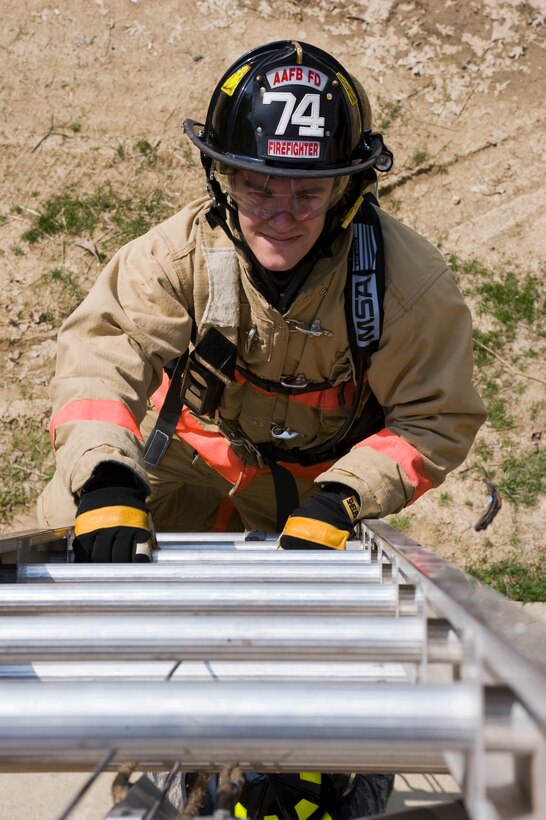 Airman Stephen Deroche, 11th Civil Engineer Squadron firefighter, ascends a 35-foot ladder on a two-story building during a portion of a ladder operations training May 2. Governed by National Fire Protection Association code 1410, the purpose of the training is to familiarize firefighters with setting up egress routes to exit structural fires. (Photo by Bobby Jones)