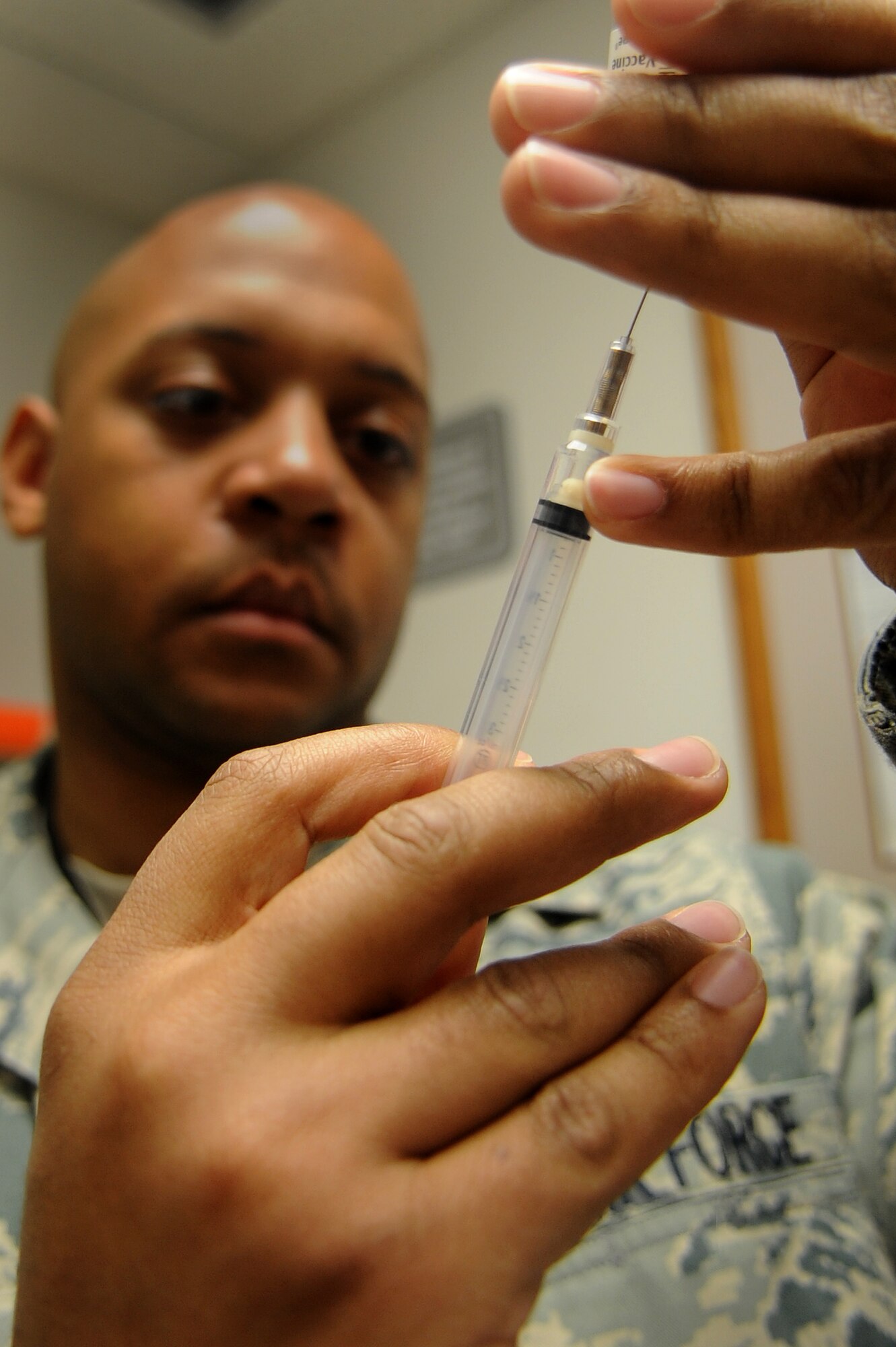 WHITEMAN AIR FORCE BASE, Mo. -- Staff Sgt. Bernard Greene, 509th Medical Operations Squadron immunizations technician, draws fluid from a syringe before administering a shot to a patient May 3, 2011. The 509th Medical Group applauds their hard working nurses and medical technicians during National Nurses and Medical Technician Week. (U.S. Air Force photo by Senior Airman Kenny Holston)(Released)


