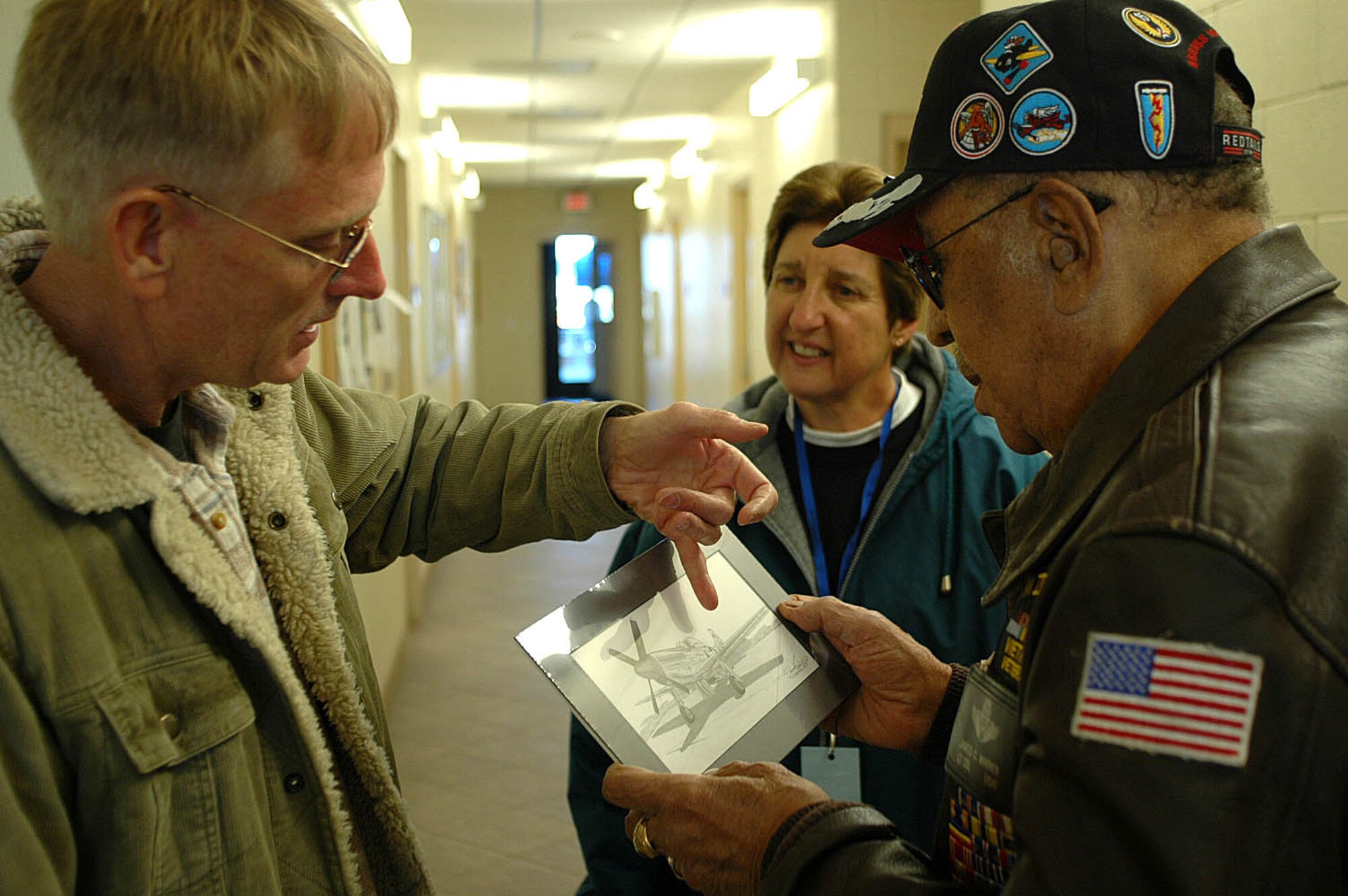 940th Wing Reservist Tech. Sgt. Doug Kinsley presents former Tuskegee Airman, retired Lt. Col. James C. Warren, a drawing of a P-51 Mustang, an aircraft flown by the Tuskegee Airmen during WWII. Lt. Col. Warren was on hand at the Beale Air Show to educate the public about the history of the Tuskegee Airmen. (U.S. Air Force photo/ Dana Lineback)